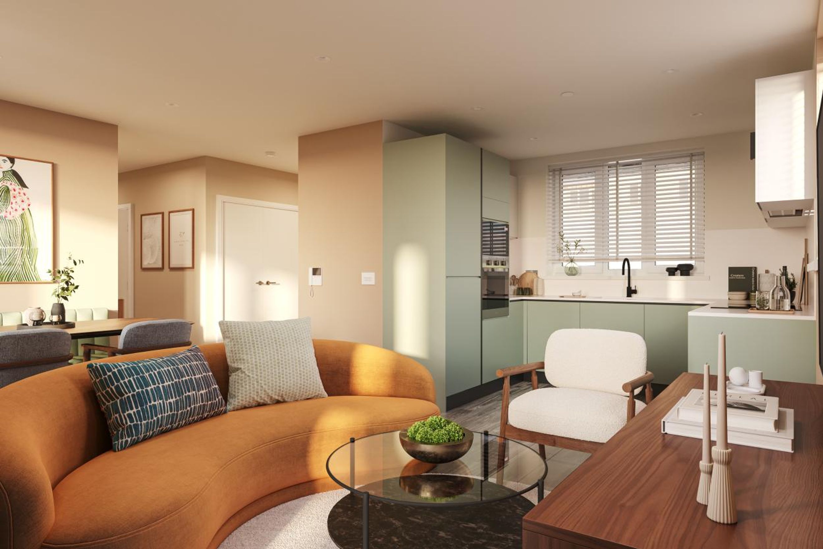A living room and kitchen area with a curved orange sofa, a white armchair, and sage green kitchen cabinets.