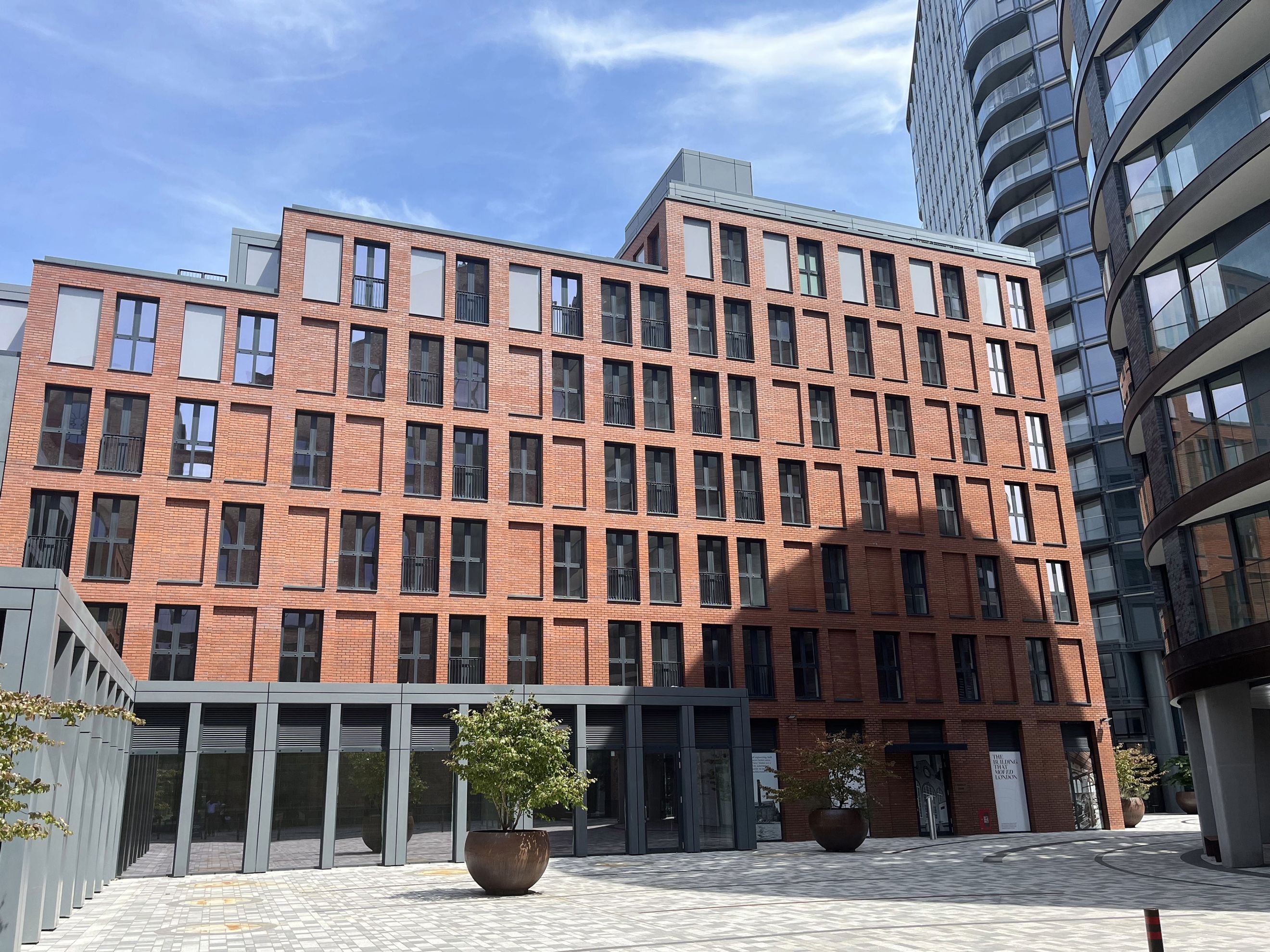 A modern brick building with many windows and balconies.