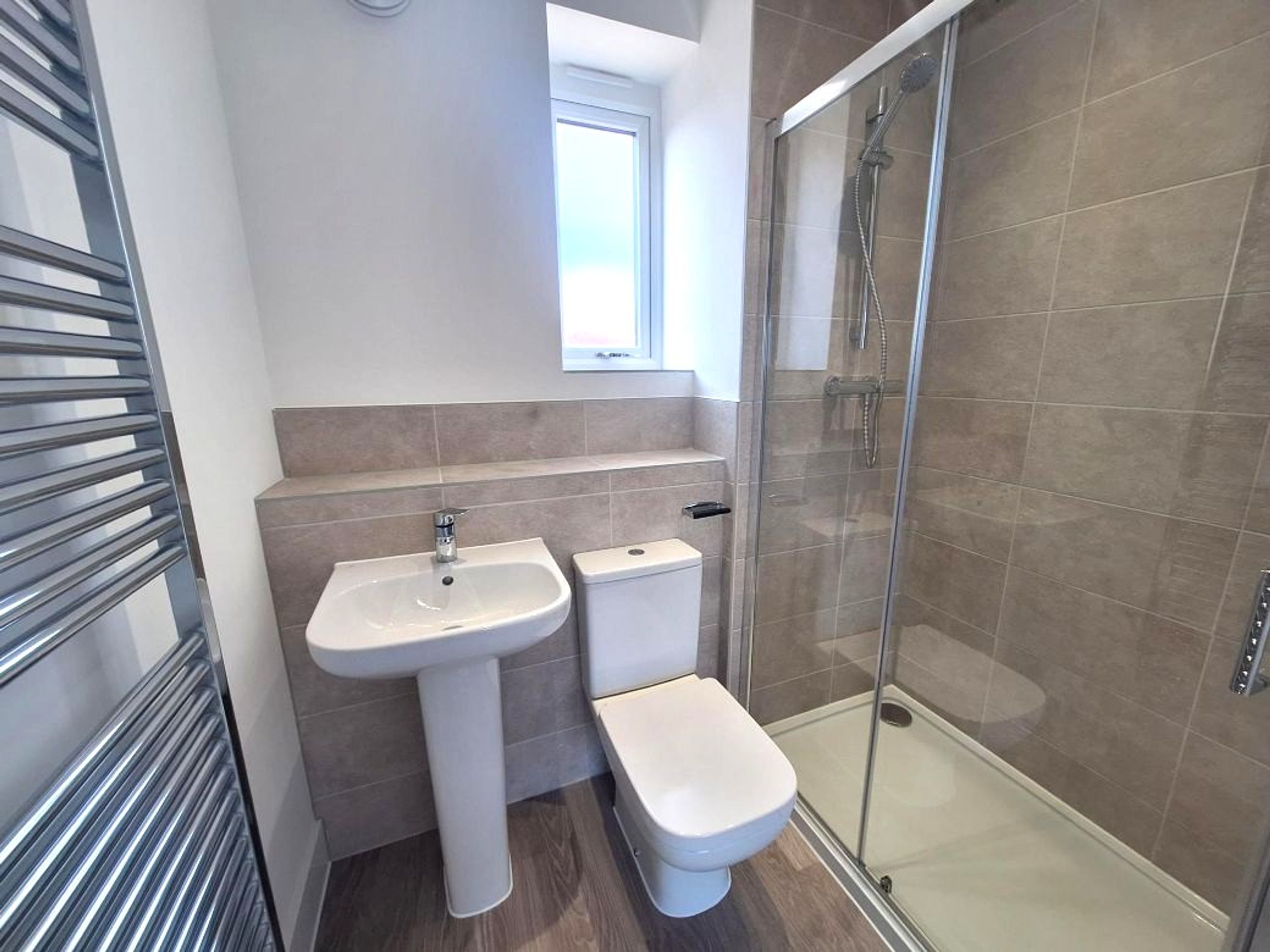 A bathroom with a sink, toilet, and shower.