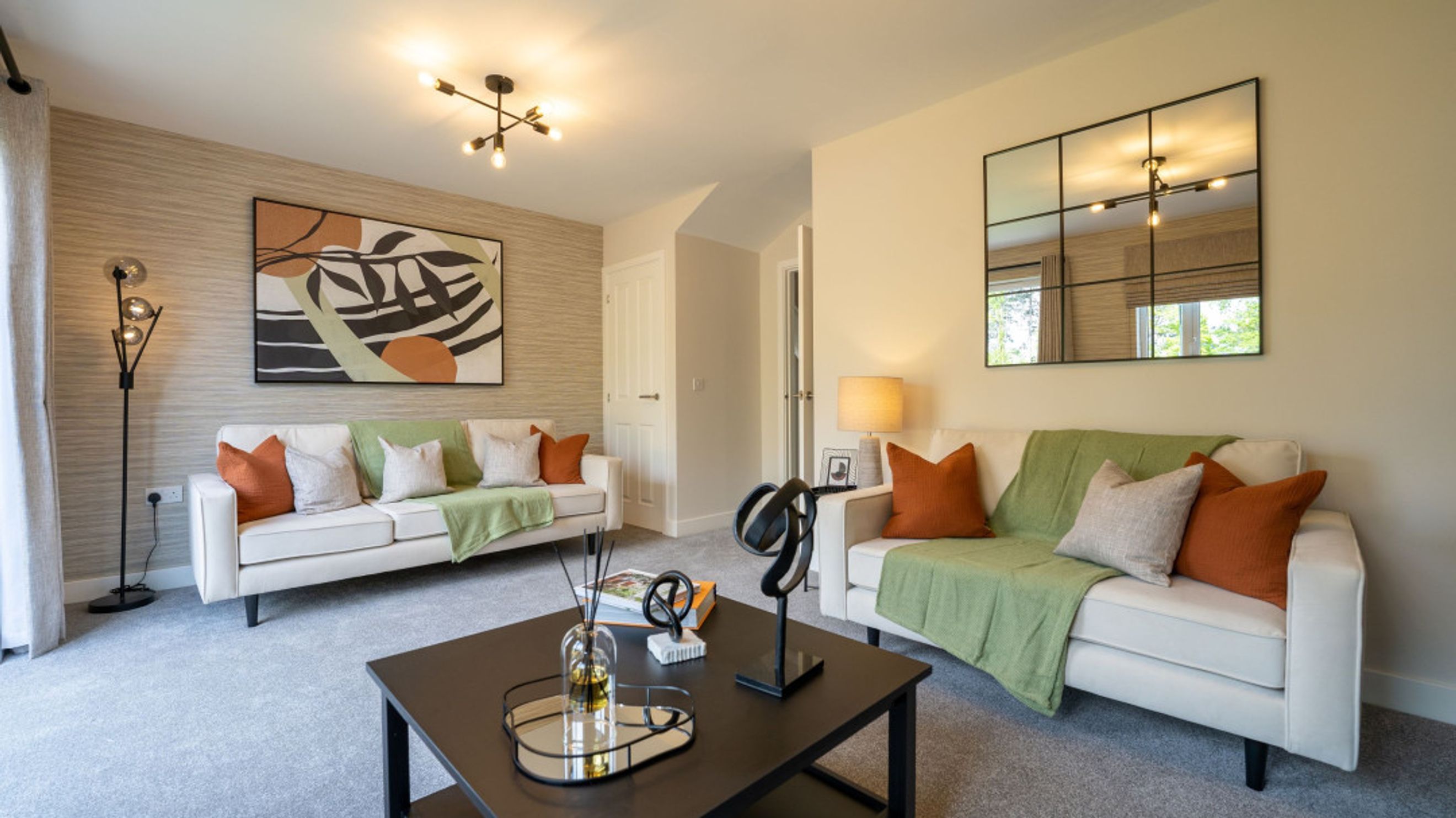 A living room with two sofas, a coffee table, and a large mirror on the wall.