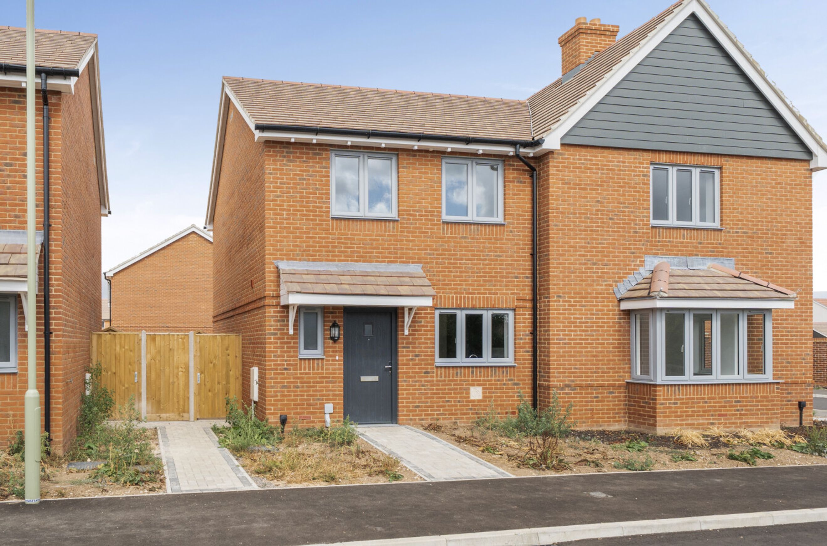 A brick house with grey windows and a tiled roof.