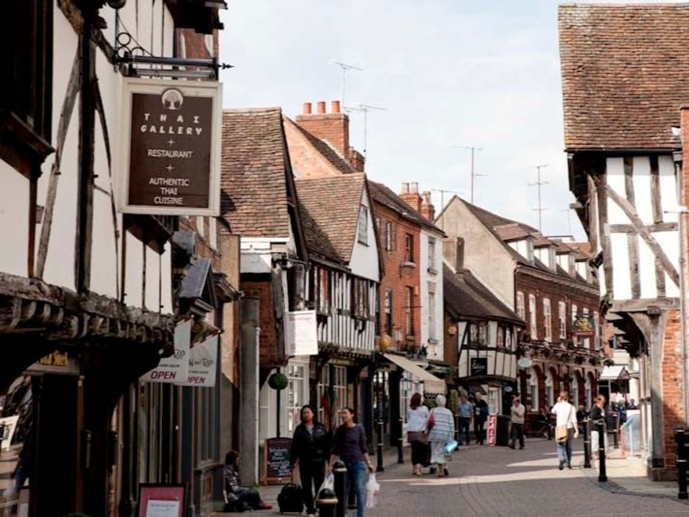 A street with historic buildings and people walking.