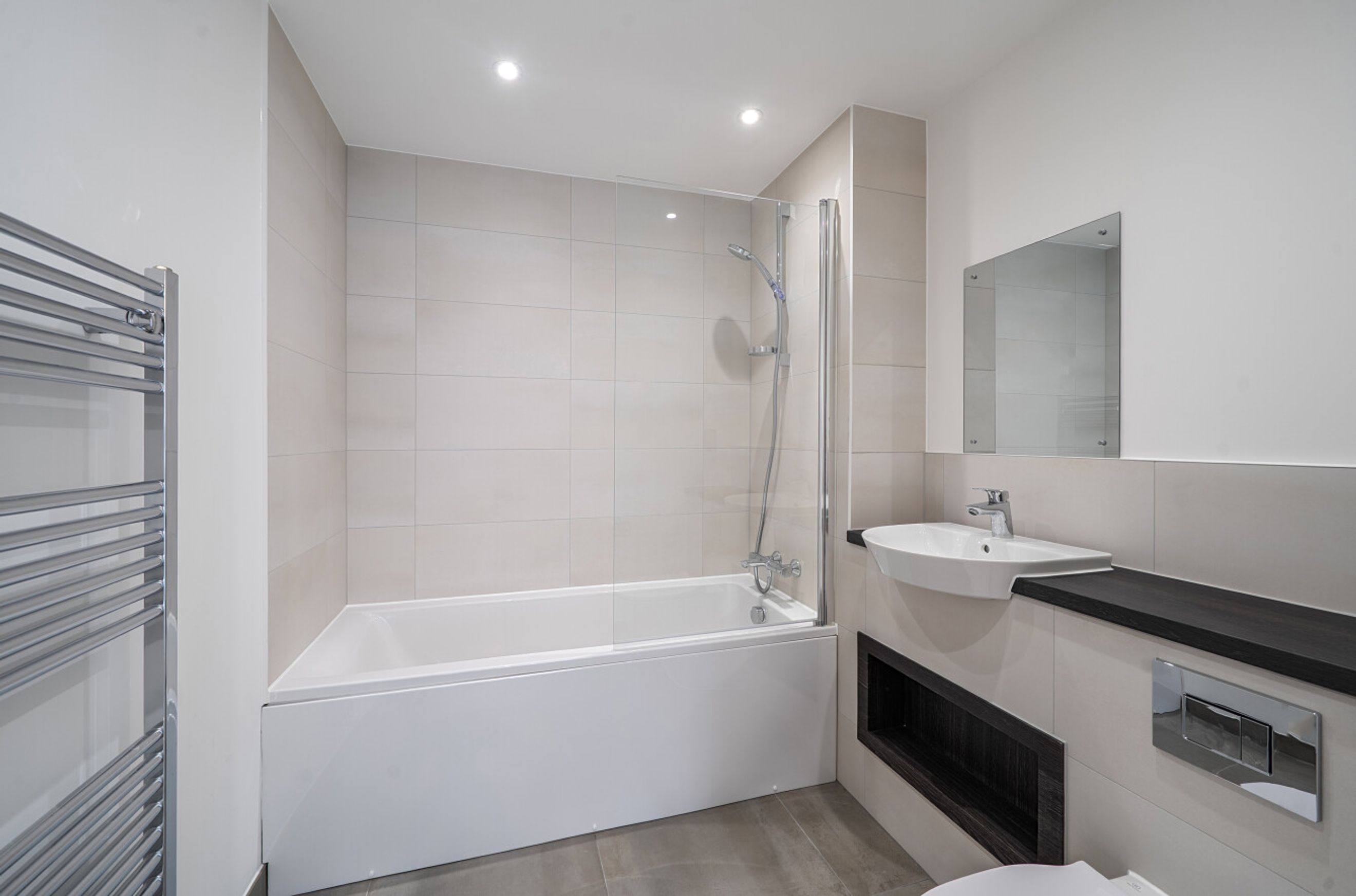 A bathroom with a bathtub, shower, sink, and mirror.