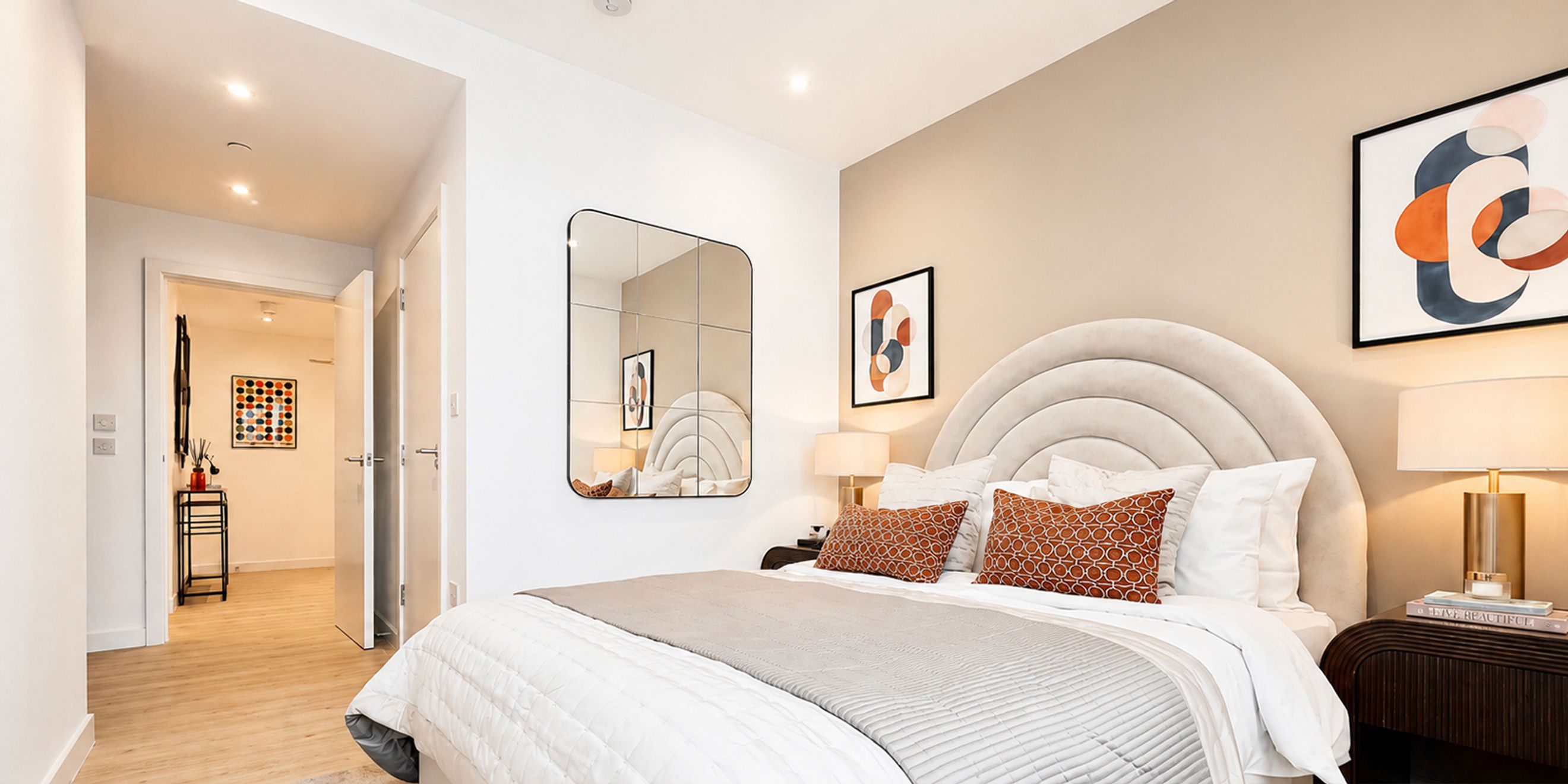 A bedroom with a bed, pillows, a headboard, and a mirror.