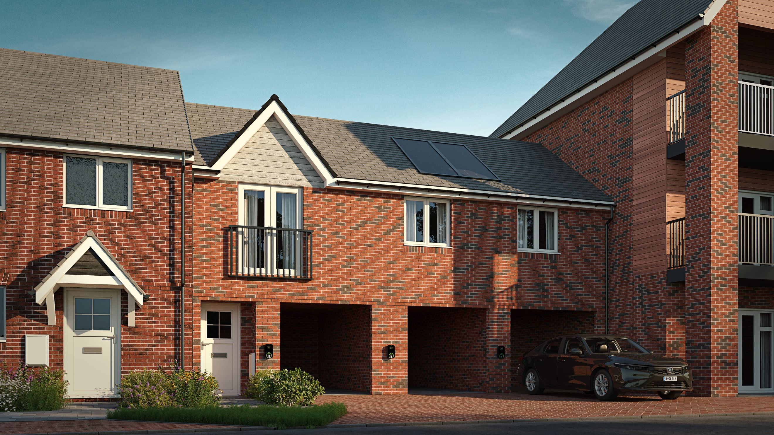A row of modern brick houses with carports and balconies under a clear blue sky.