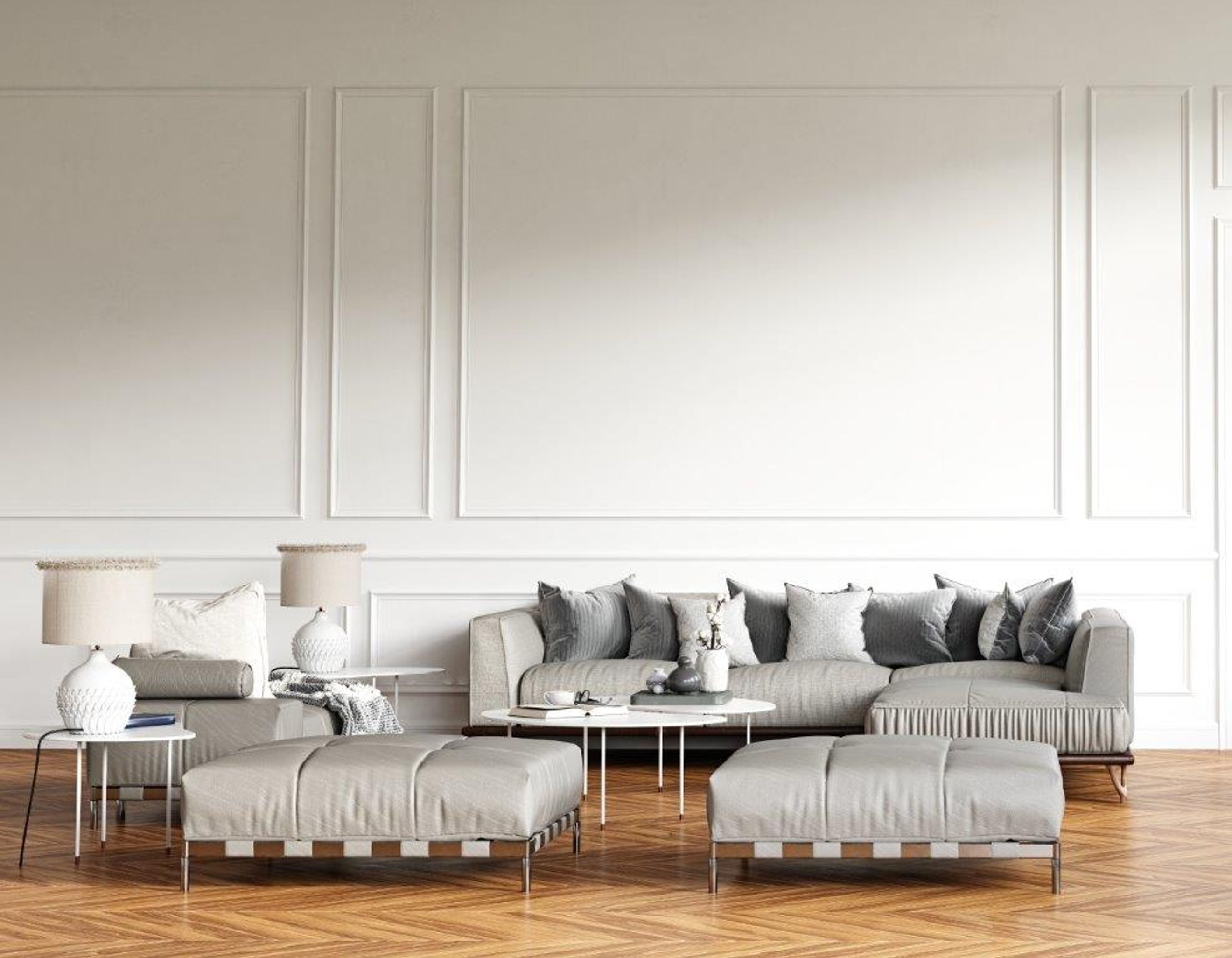 A living room with a sectional sofa, two ottomans, and two table lamps.