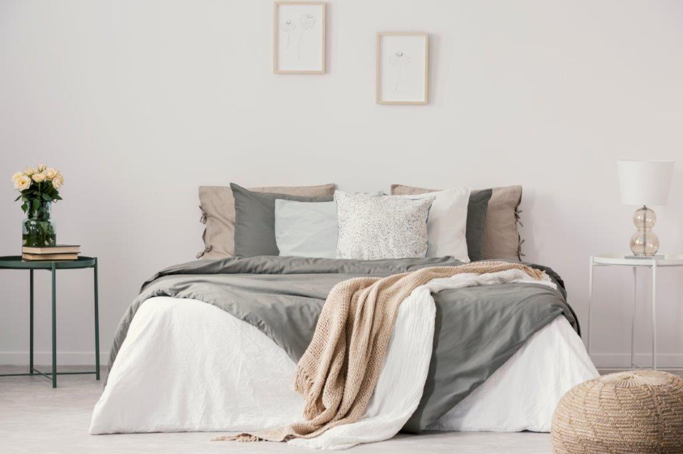 A bedroom with a bed, pillows, blankets, and a bedside lamp.