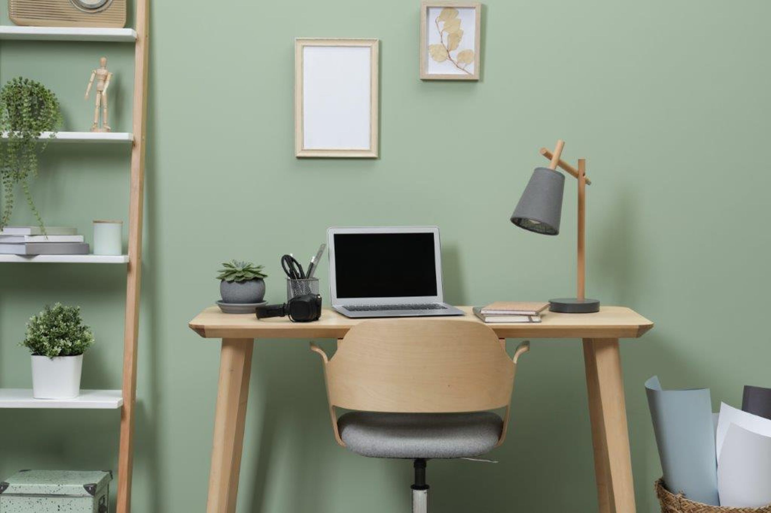A home office with a desk, laptop, chair, and shelves.