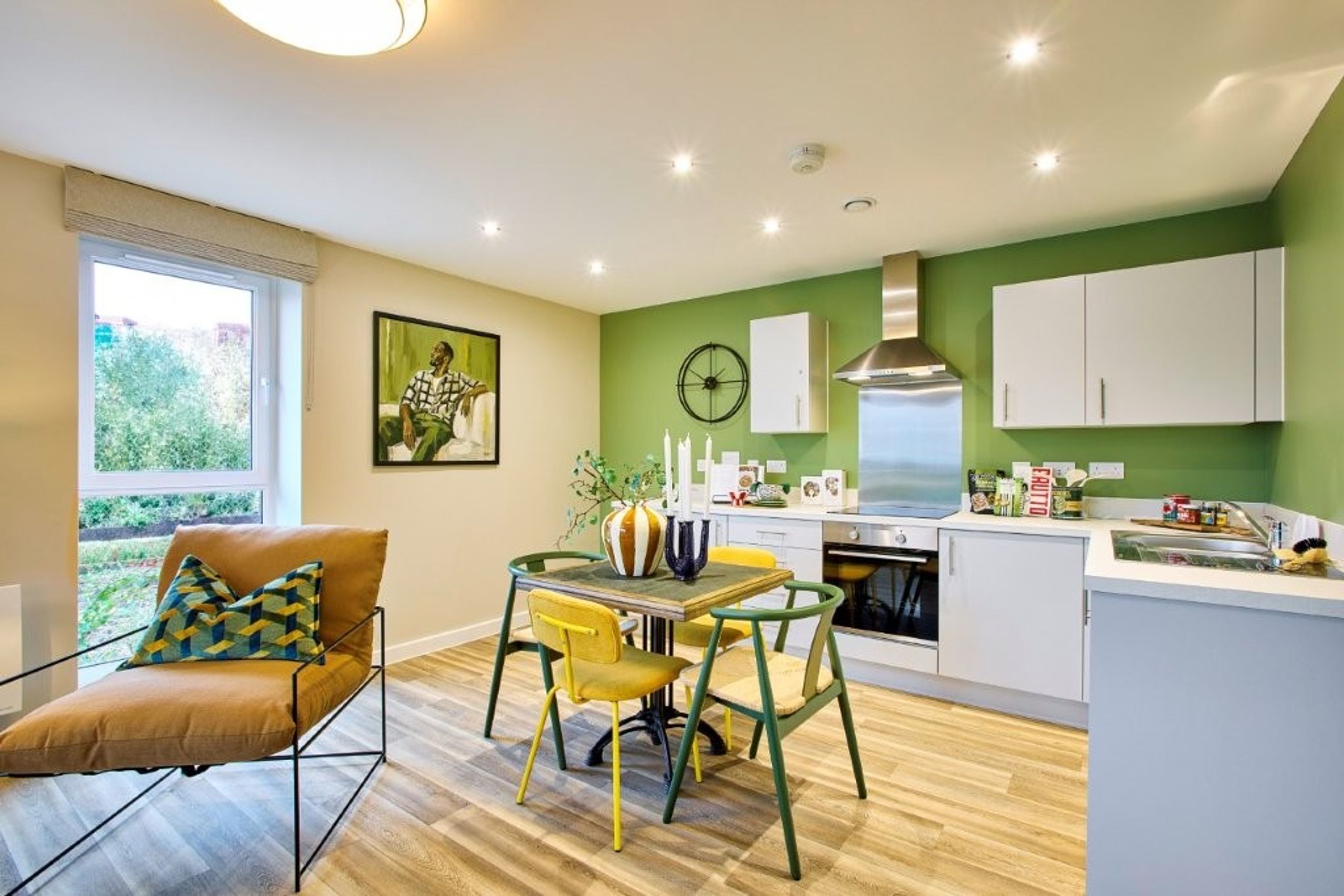 A dining area and kitchen with chairs, a table, and kitchen appliances.