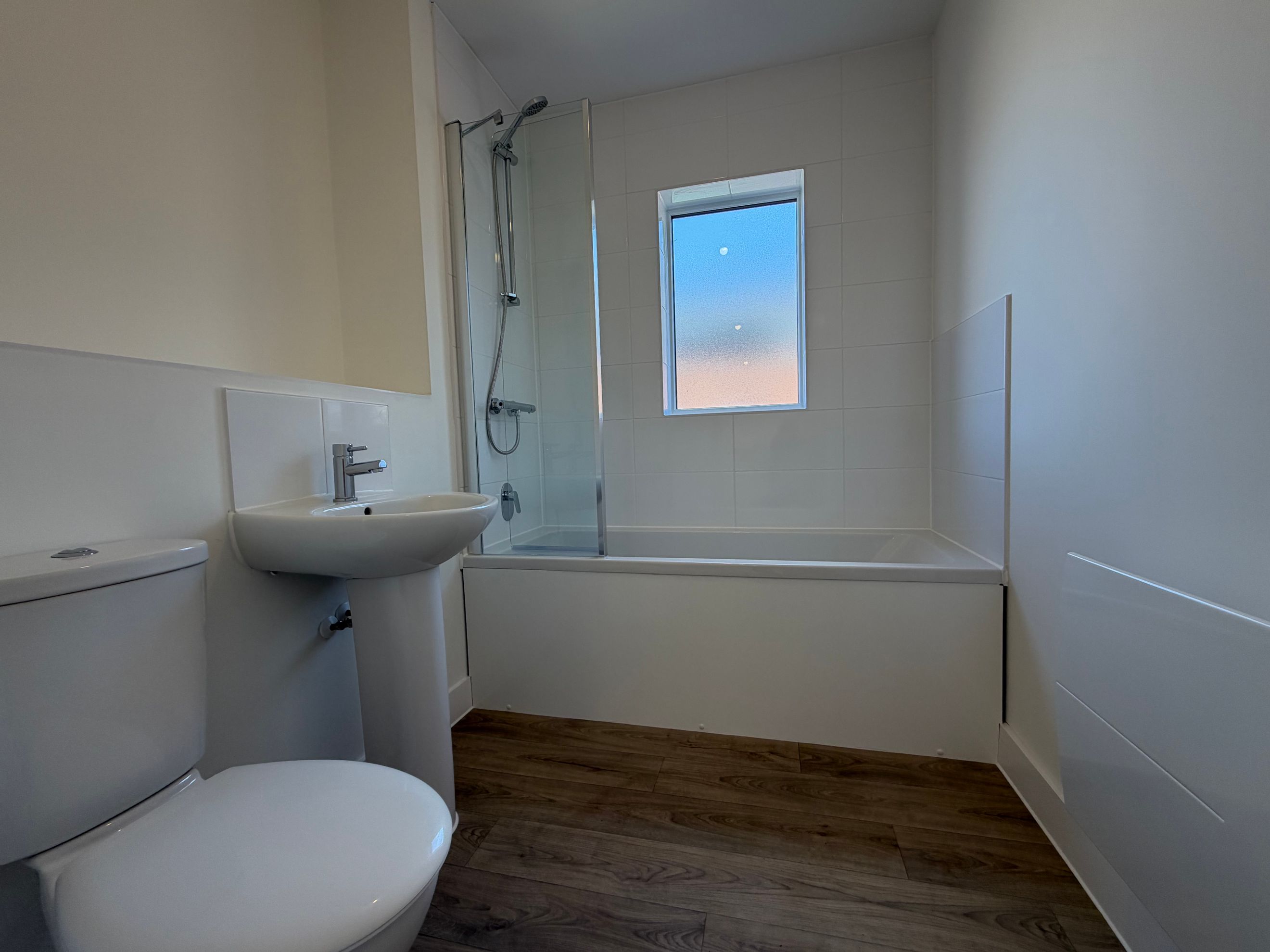 A bathroom with a toilet, sink, and bathtub.