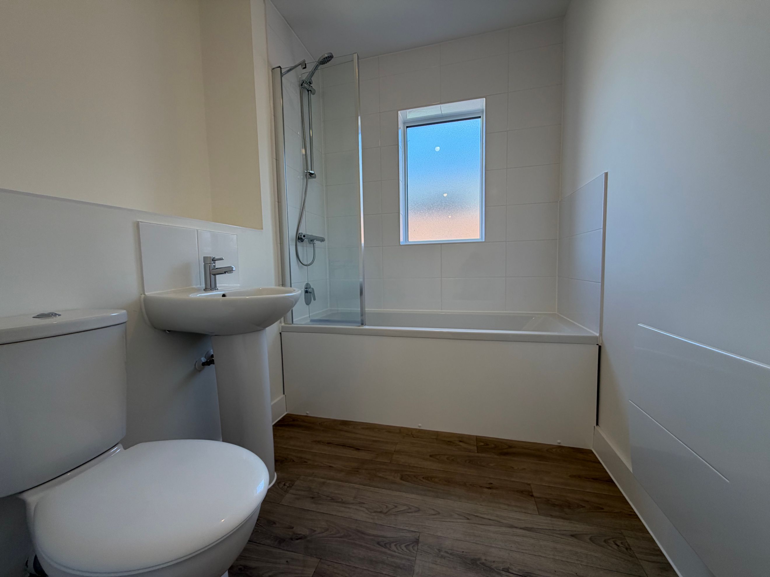 A bathroom with a toilet, sink, and bathtub.