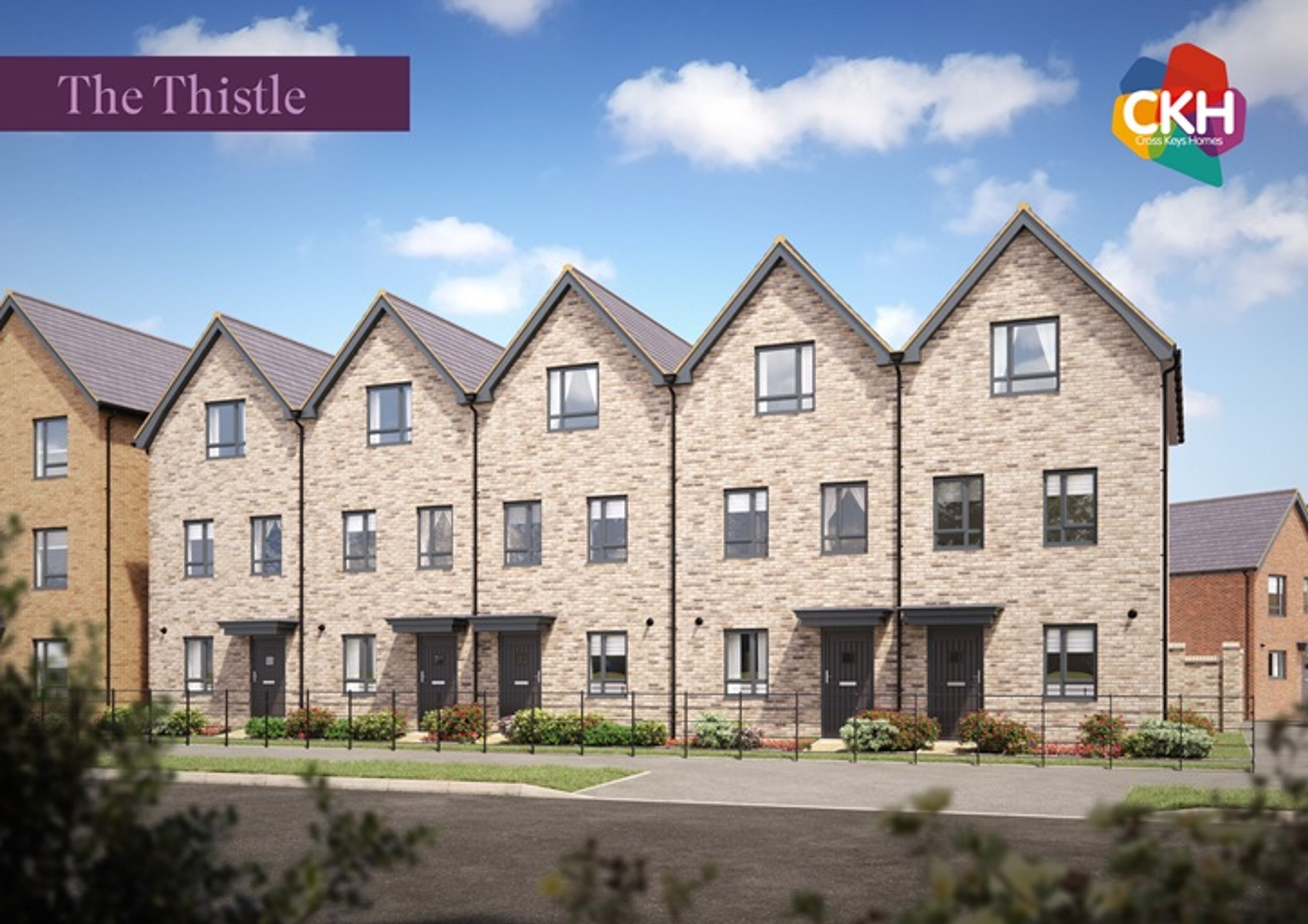 A row of modern brick townhouses with dark roofs and windows under a blue sky with clouds.