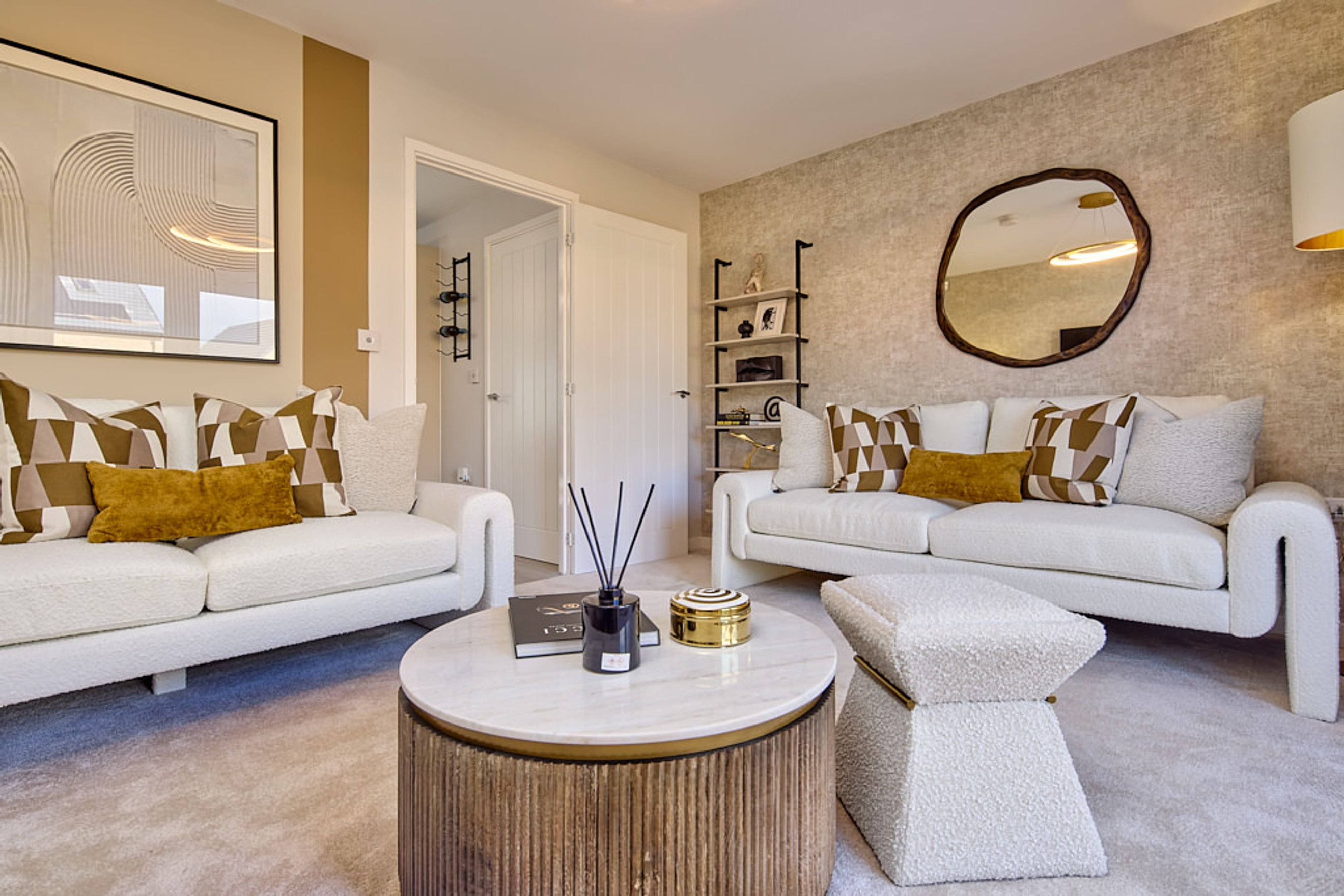 A living room with two white sofas, a coffee table, and a mirror.