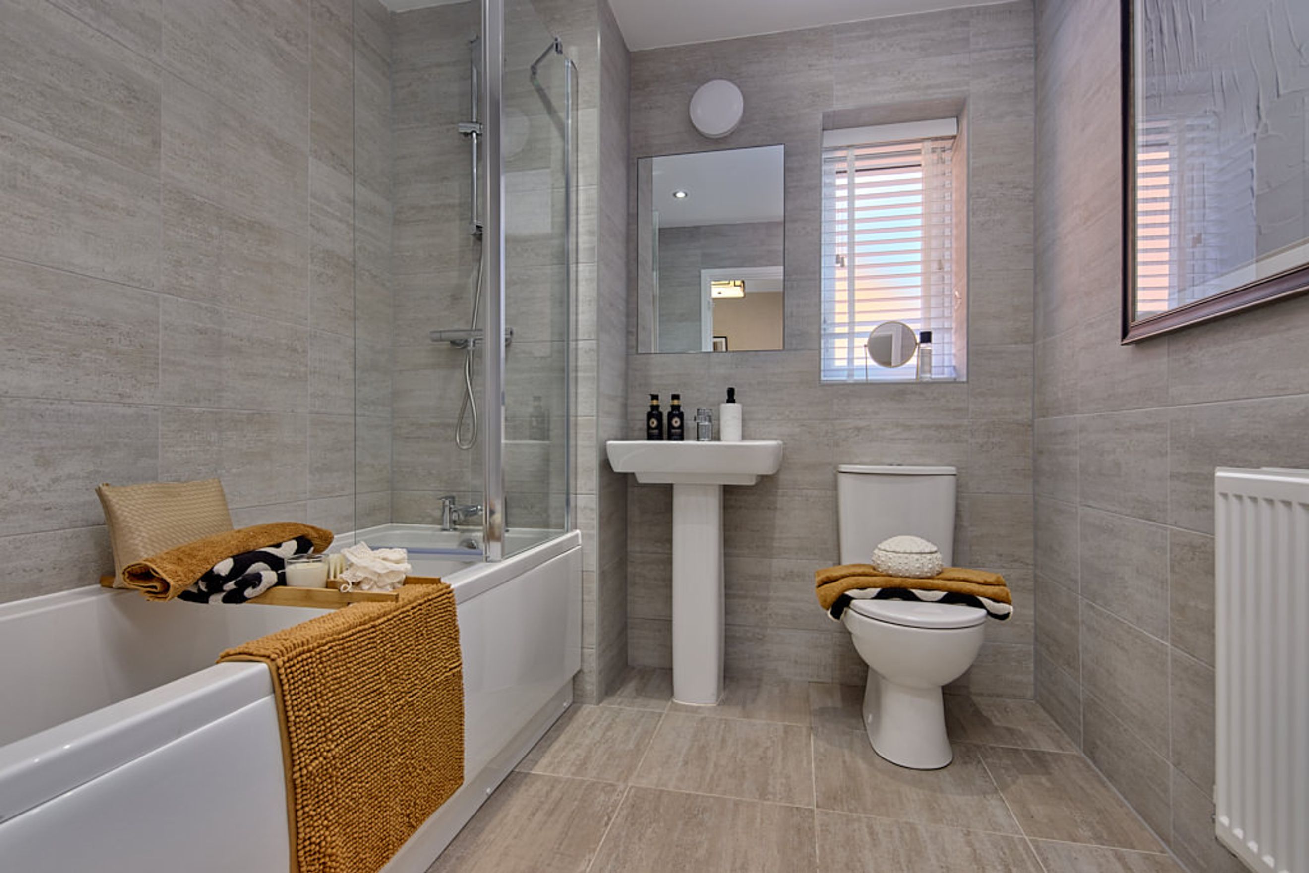 A bathroom with a bathtub, shower, sink, and toilet.