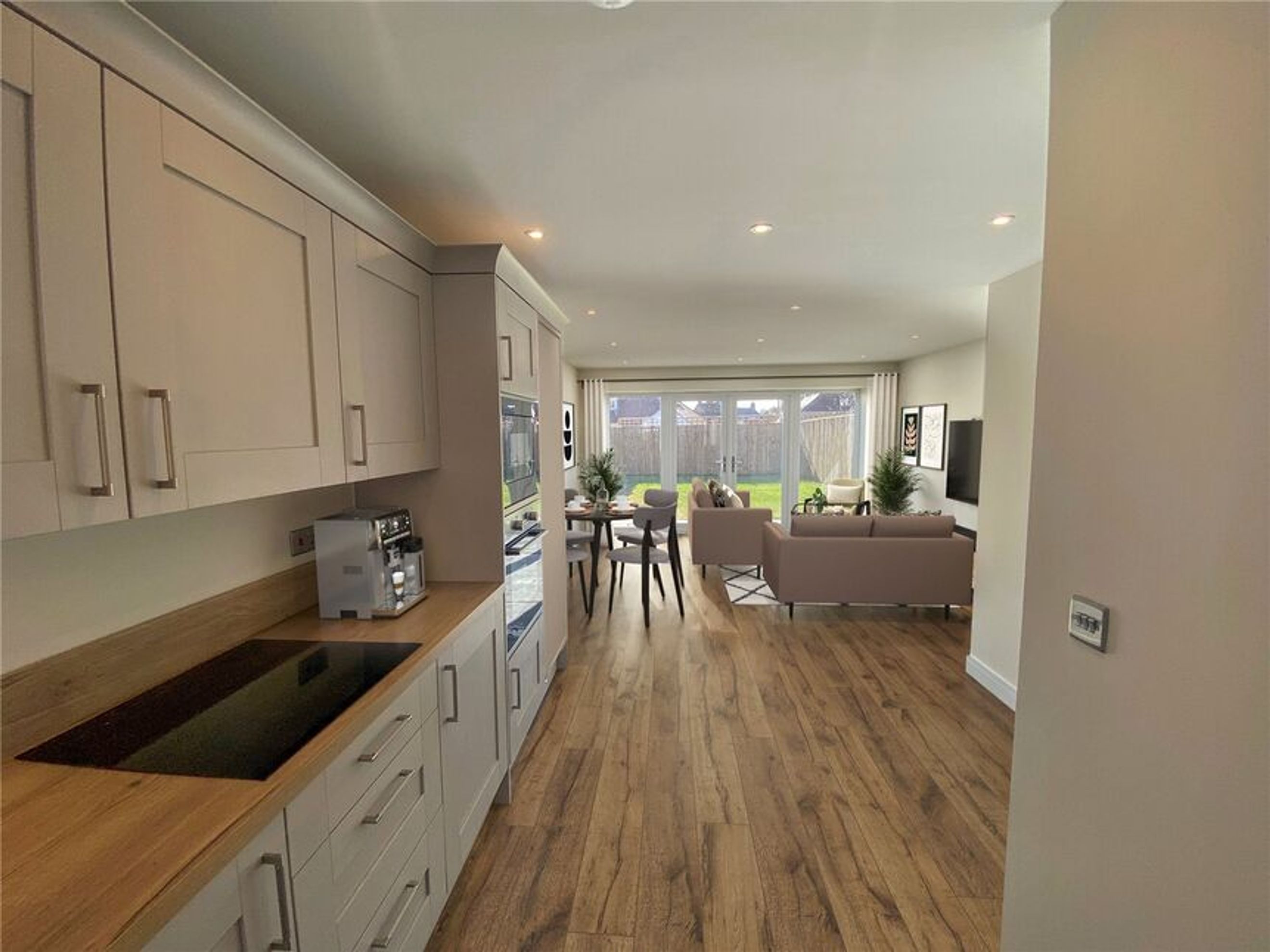 A kitchen and living area with a dining table, sofas, and a backyard view.