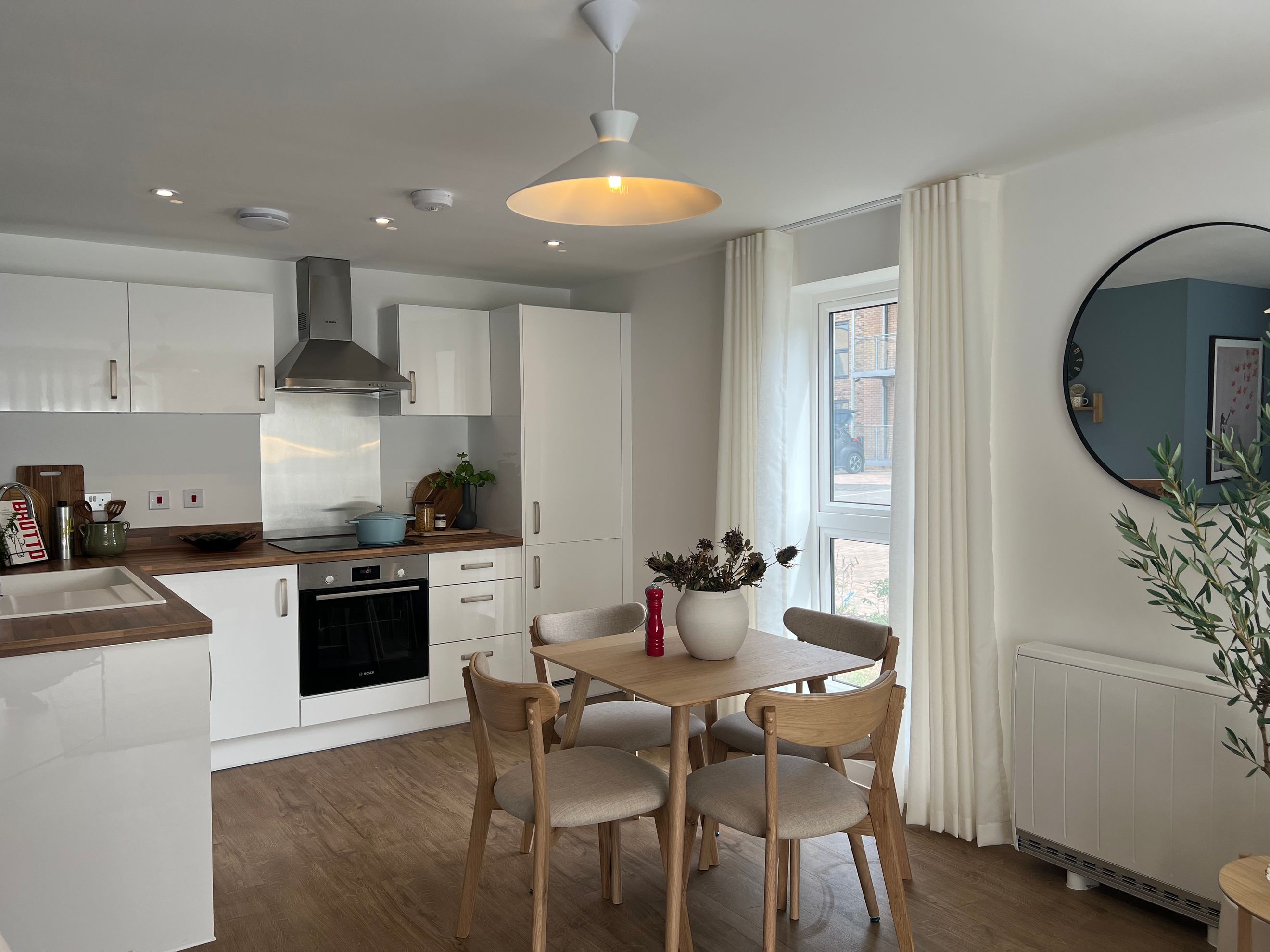 A kitchen and dining area with white cabinets, a dining table, and chairs.