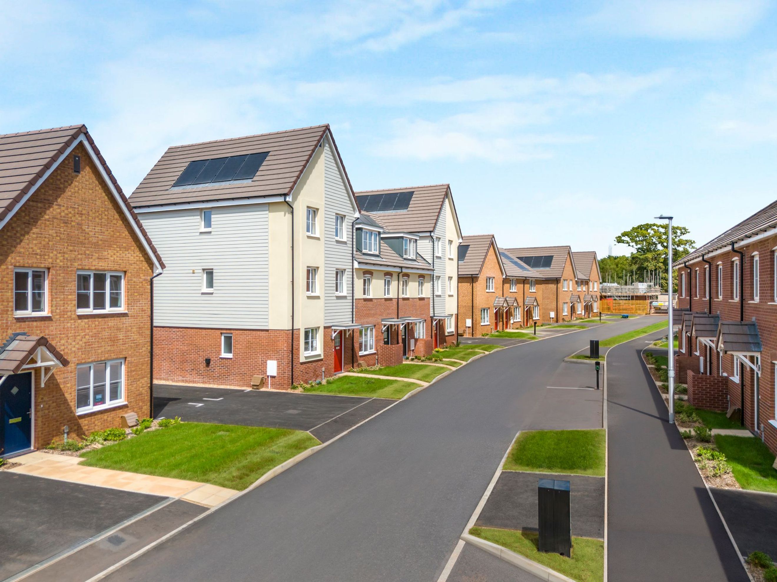A street lined with new houses with solar panels on the roofs.