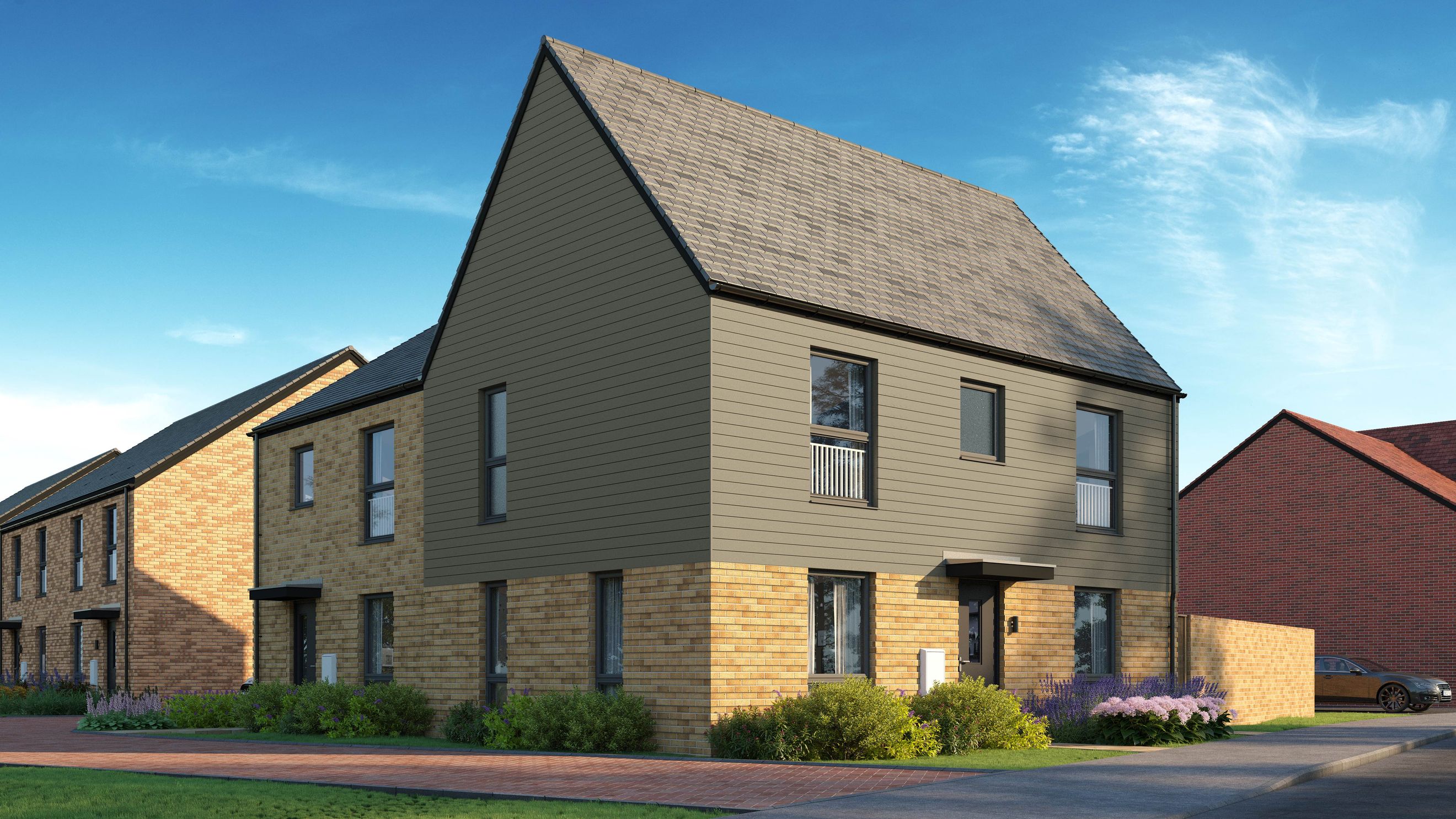 A modern house with brick and grey siding, featuring multiple windows and a pitched roof.