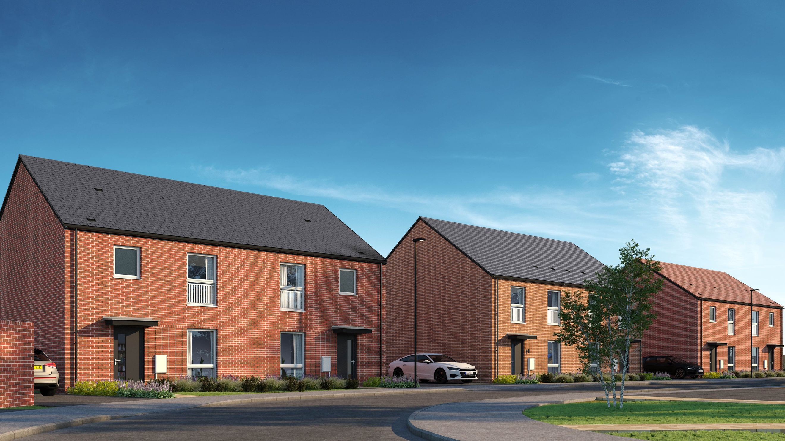 A row of modern brick houses with dark roofs and driveways under a blue sky.