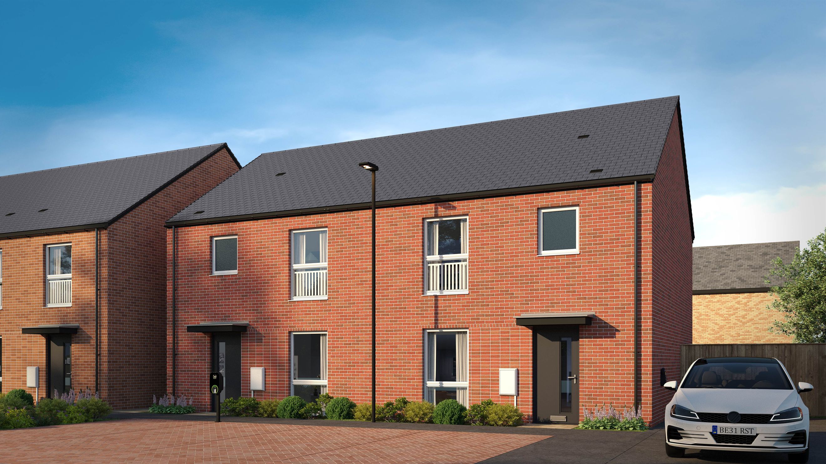 A row of modern red brick townhouses with grey roofs, windows, doors, and a car parked in the driveway.