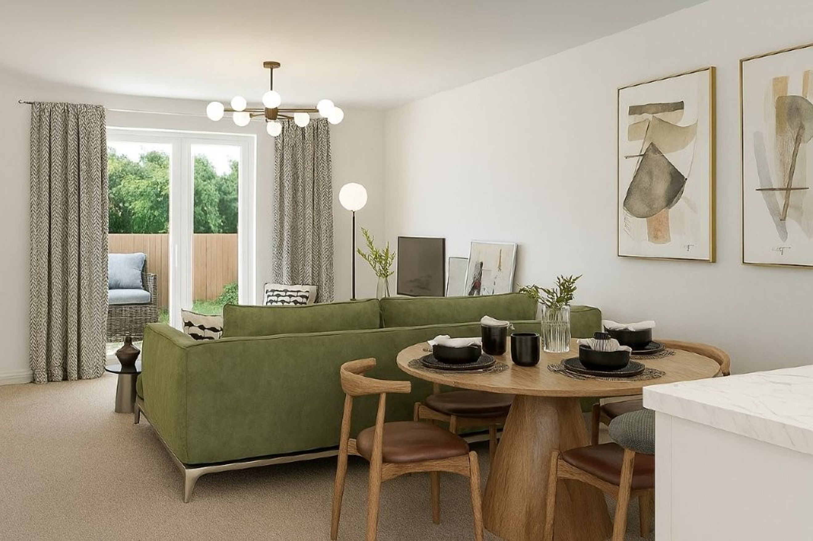 A living and dining area with a green sofa, a round dining table, and abstract art on the wall.