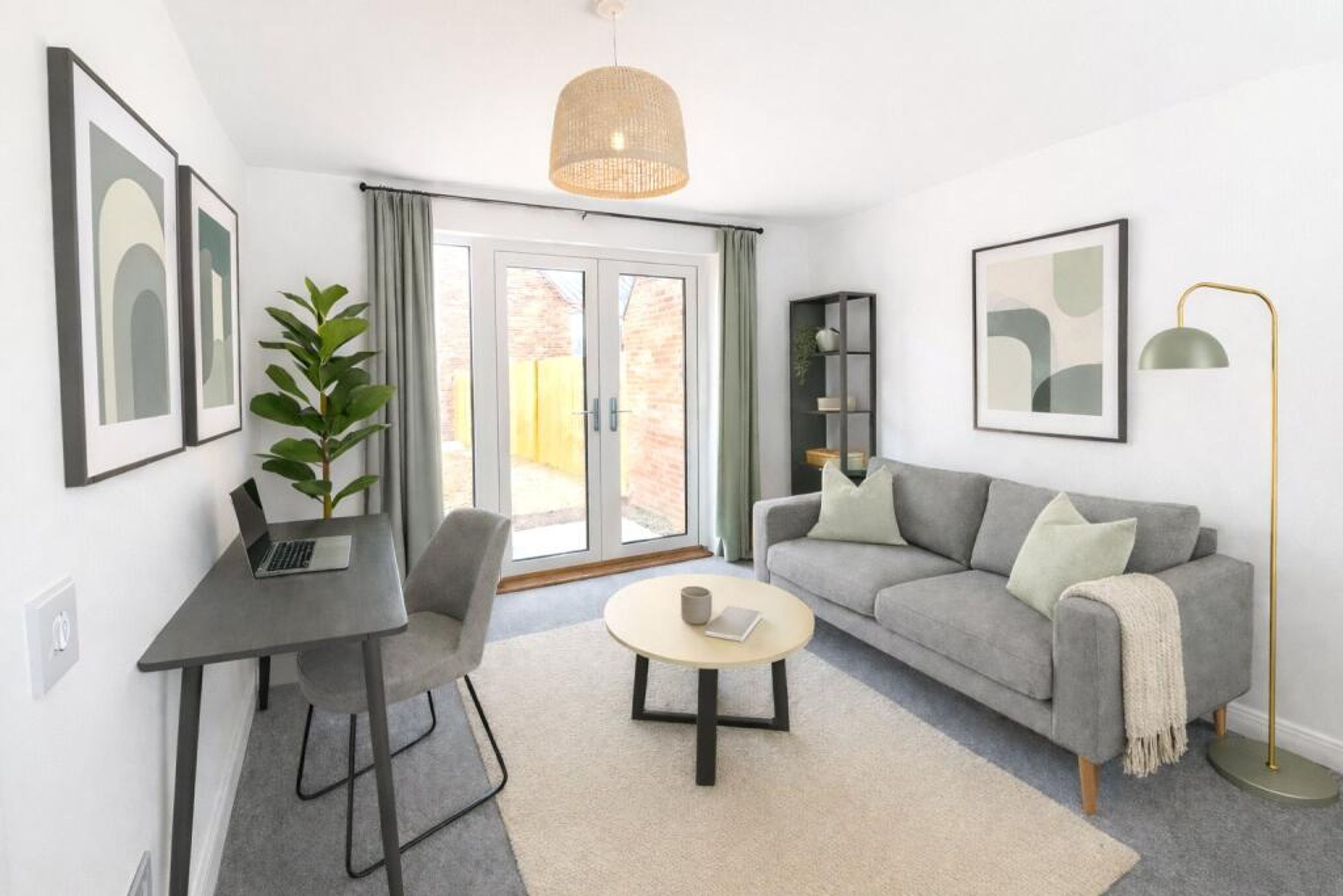 A living room with a sofa, coffee table, desk, and artwork.