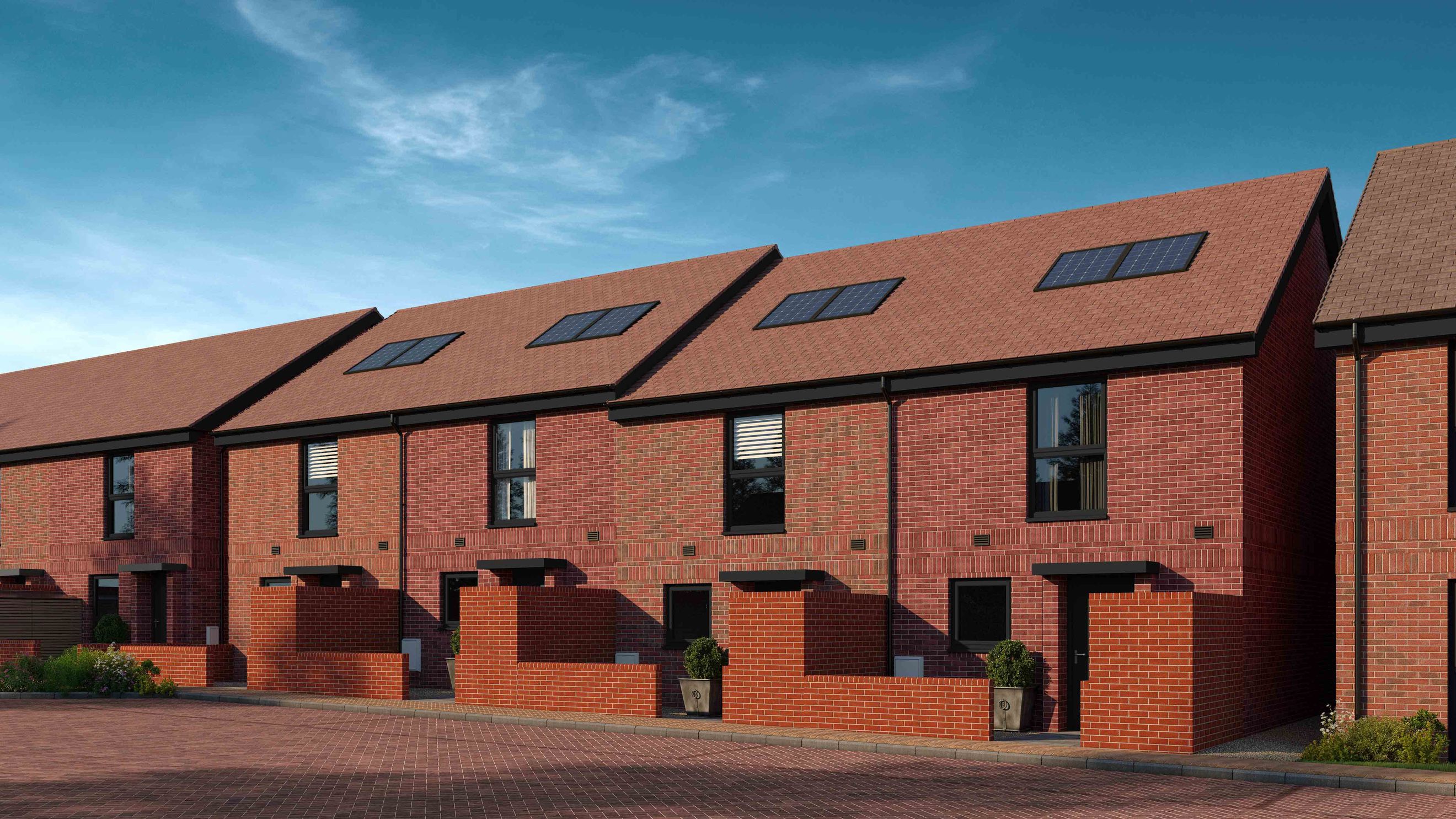 A row of modern brick townhouses with solar panels on the roof.