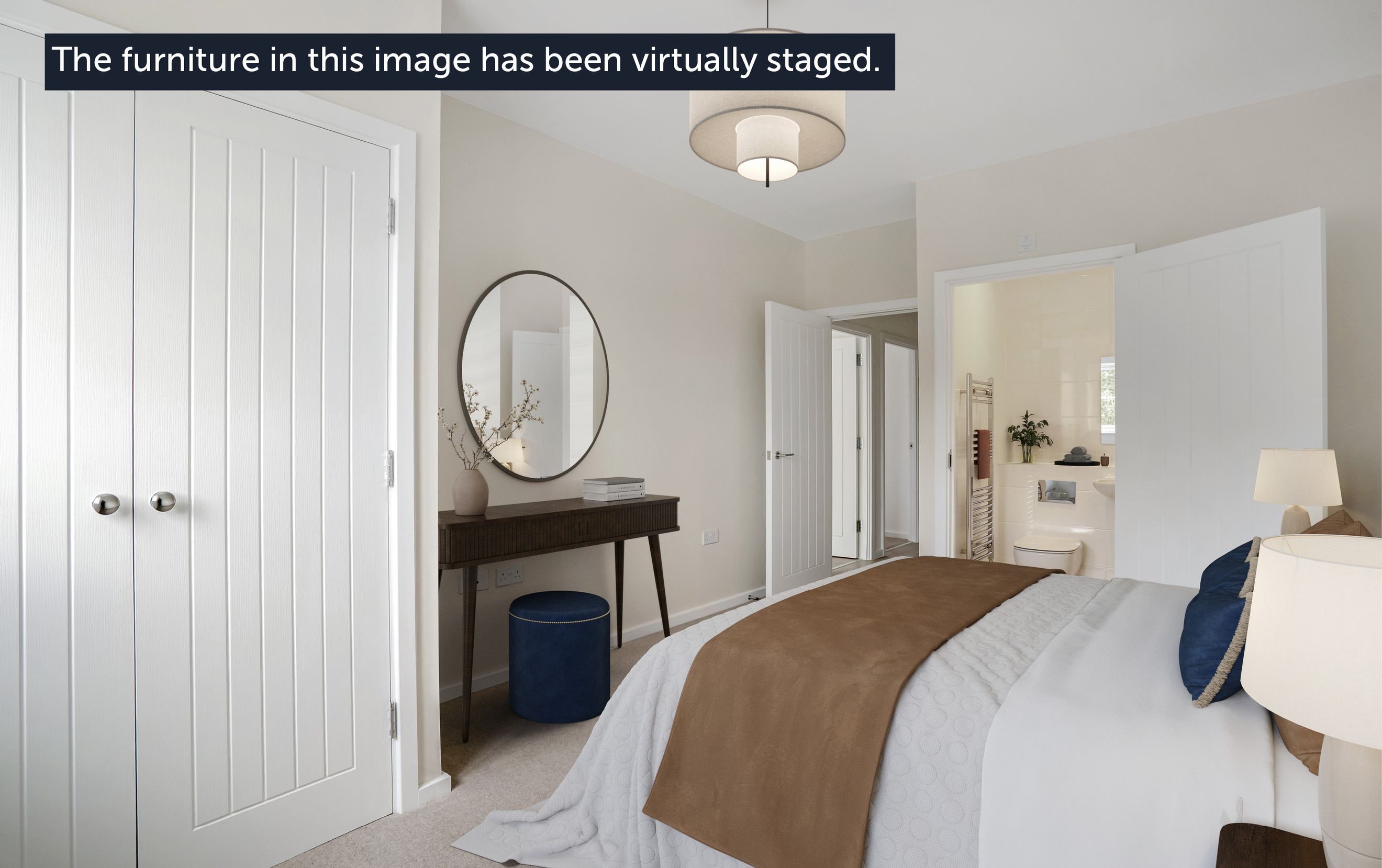 A bedroom with a bed, a console table, a mirror, an ottoman, and an en-suite bathroom.