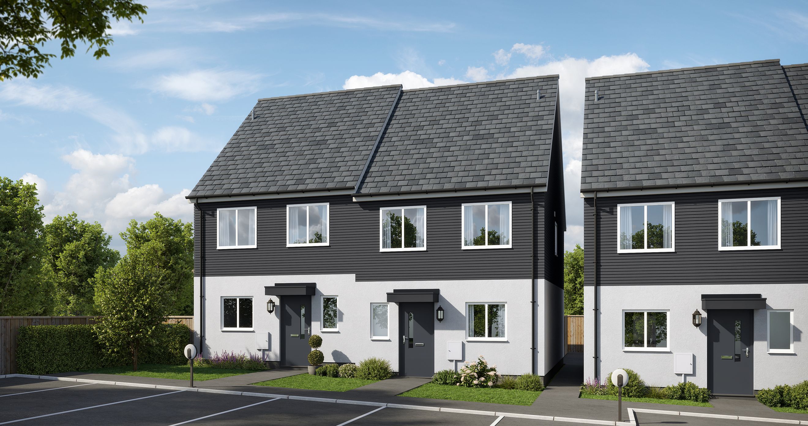 A row of modern semi-detached houses with dark siding and white trim, parked cars, and green landscaping.