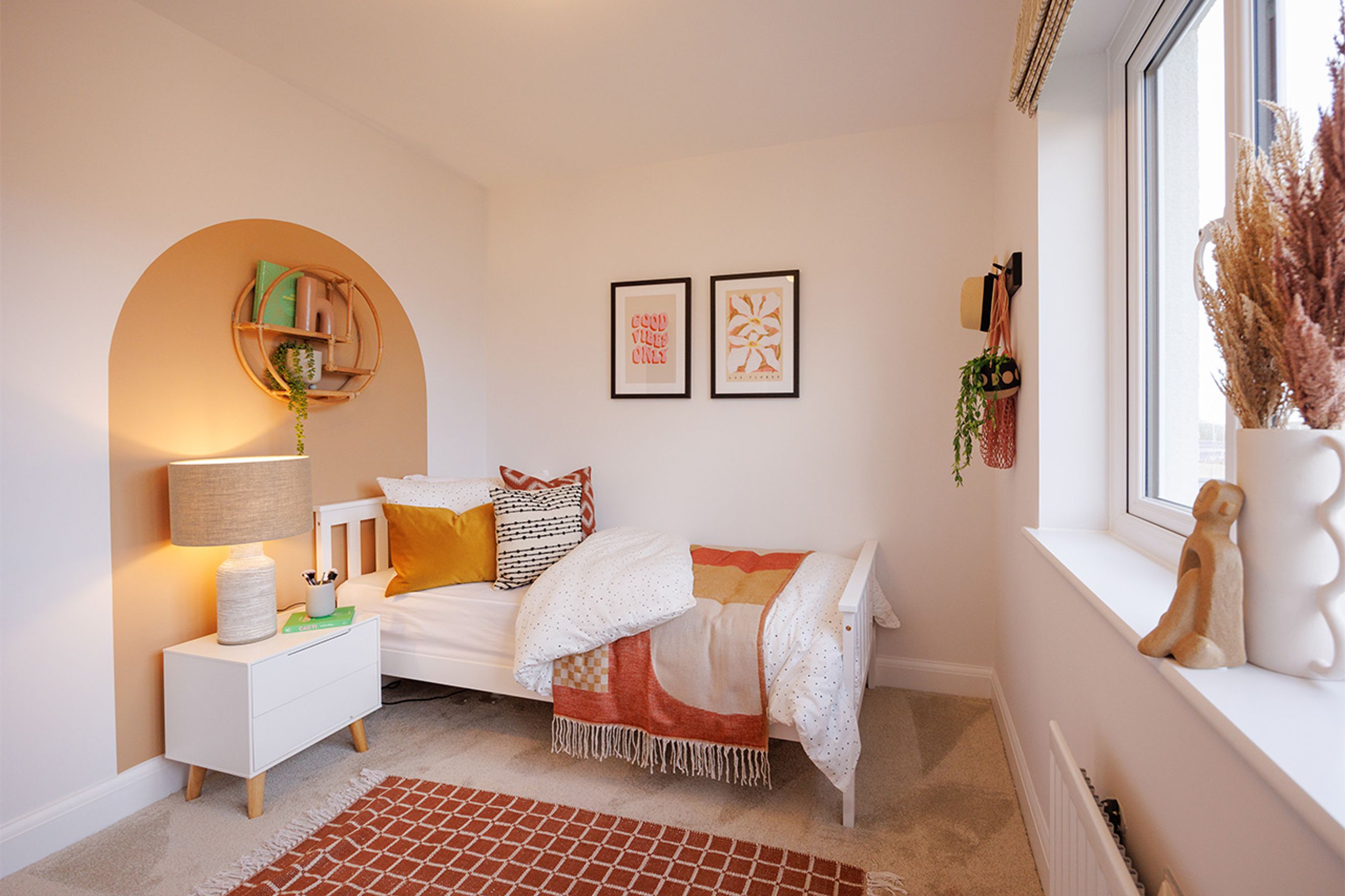A bedroom with a single bed, bedside table, and decorative wall art.