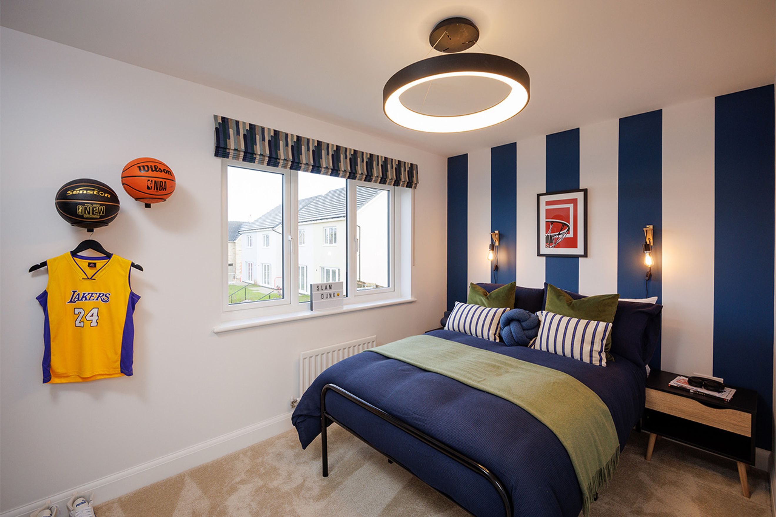 A bedroom with a bed, basketballs, and a Lakers jersey.