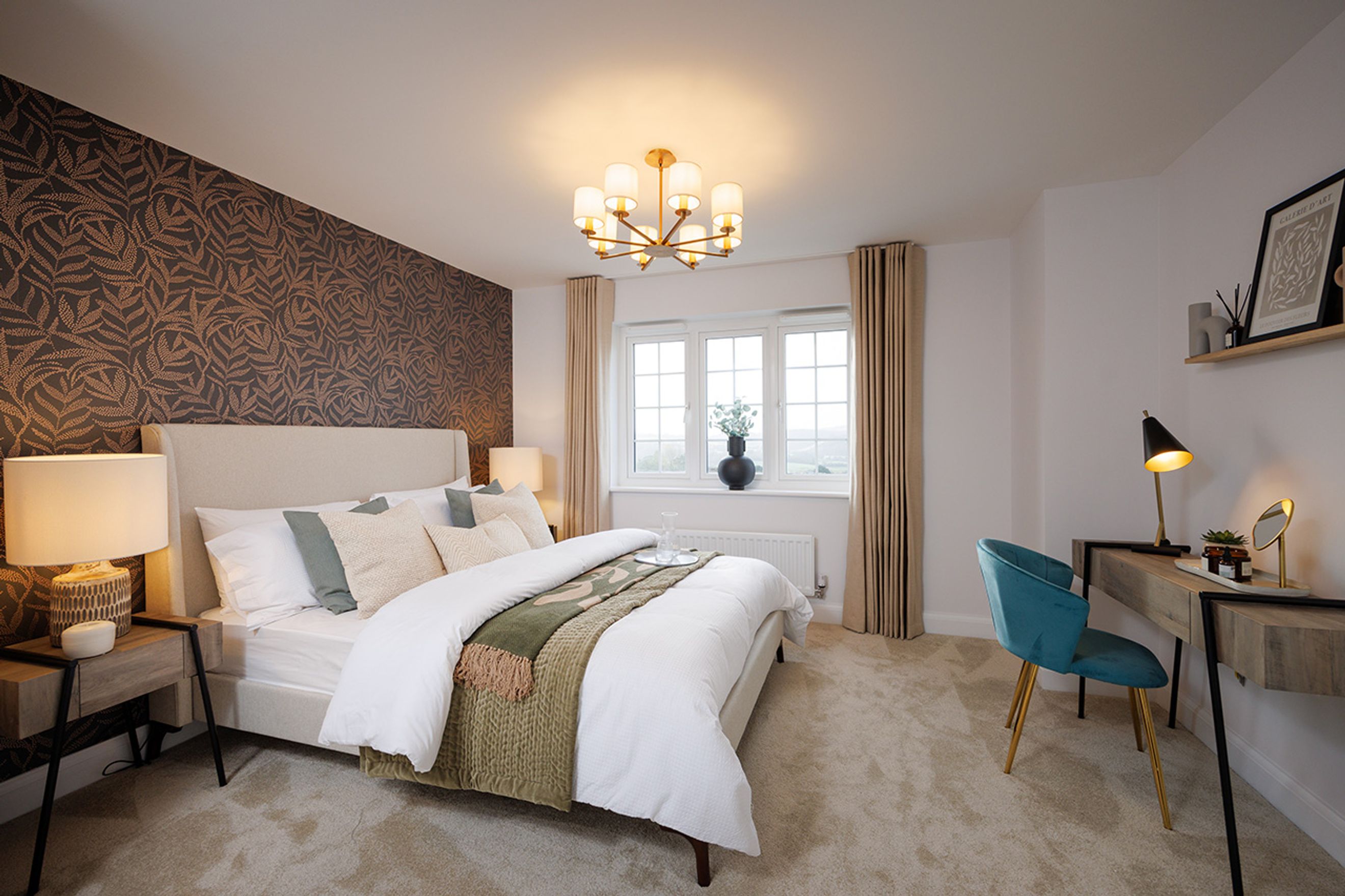 A bedroom with a bed, wallpaper, a desk, and a window.