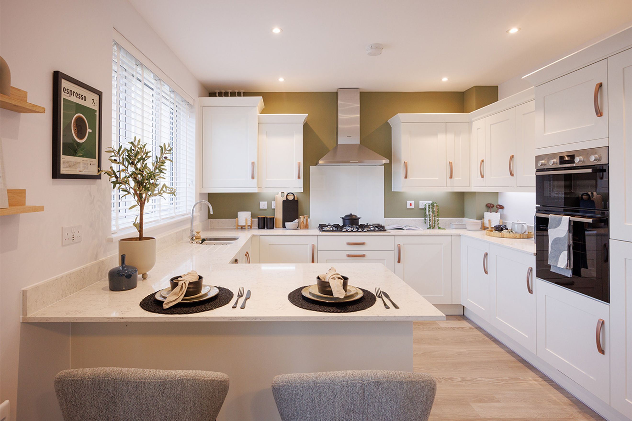 A modern kitchen with white cabinets, a quartz countertop island, and a gas hob.