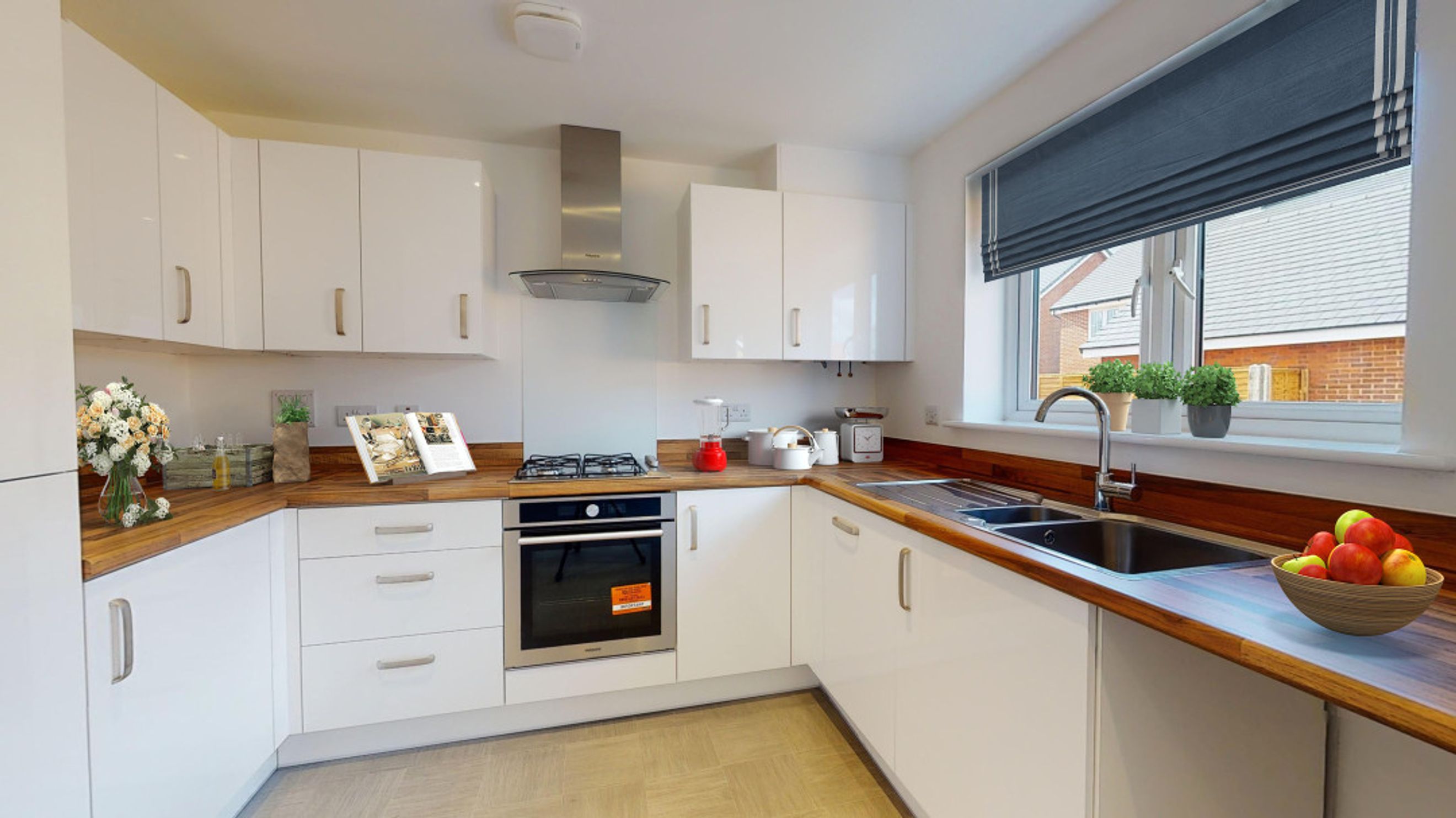 A modern kitchen with white cabinets, wooden countertops, a gas range, and a sink.