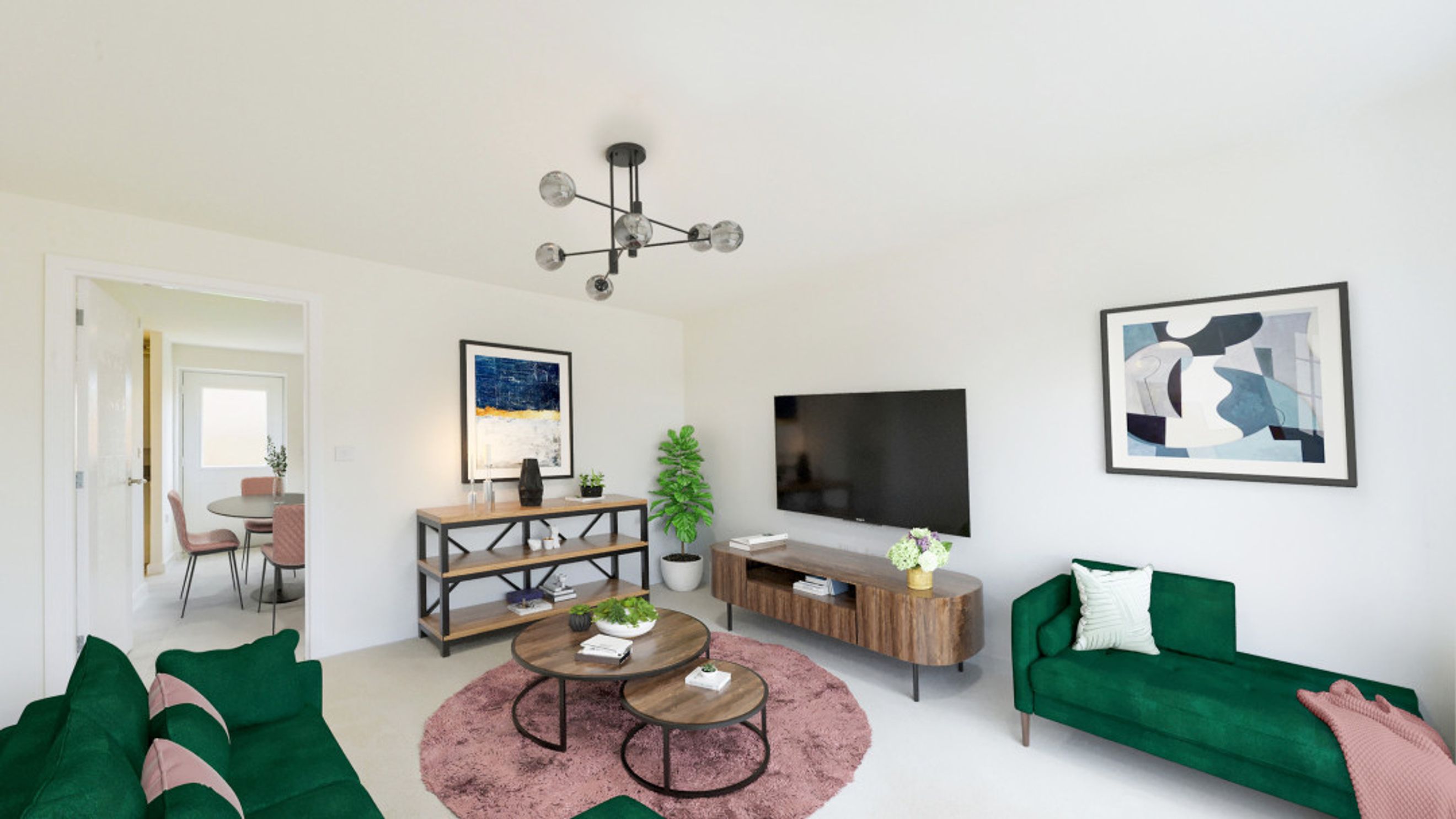 A living room with a green sofa, a chaise lounge, a TV, and a dining area visible through a doorway.