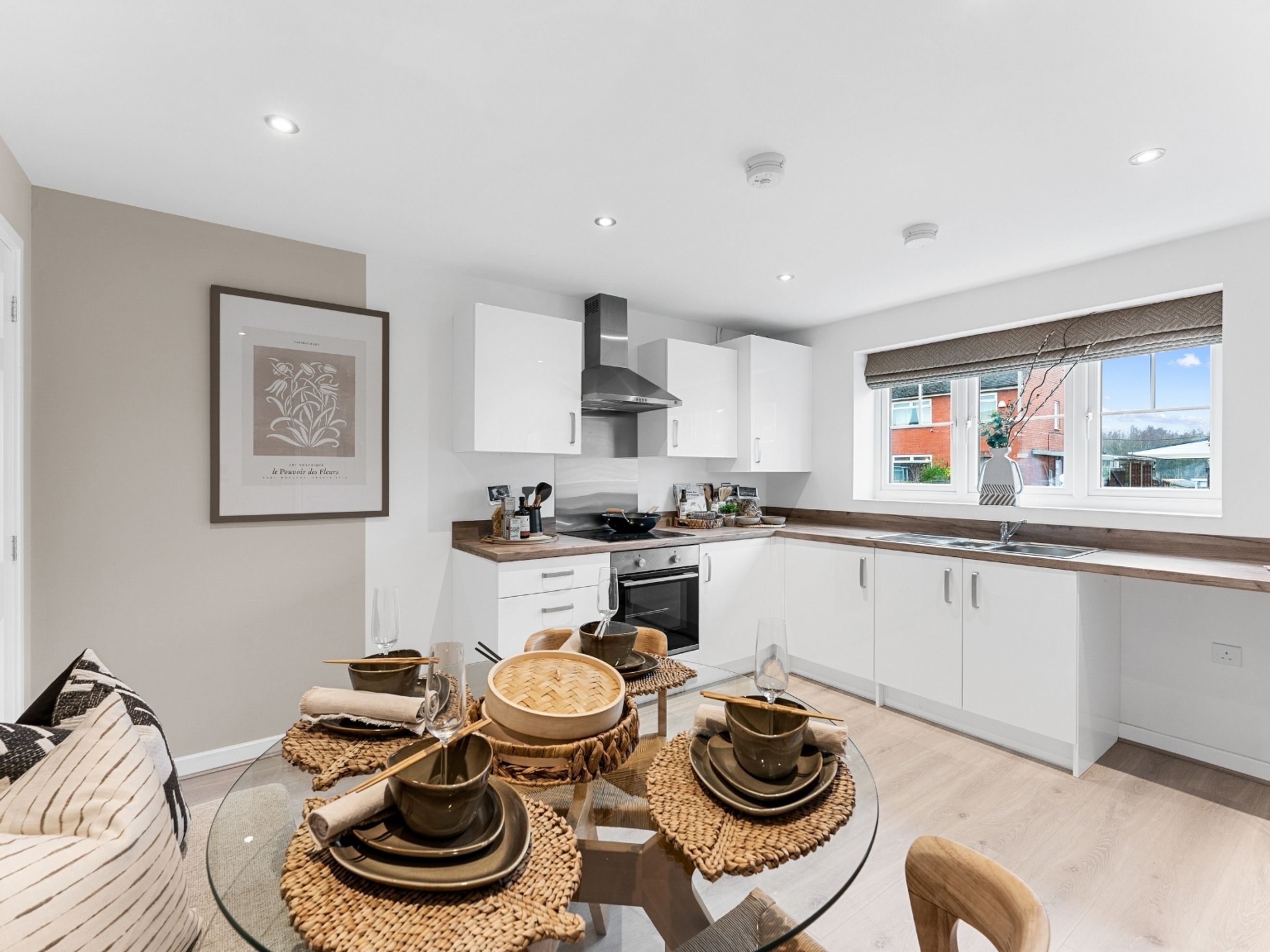 A dining area and kitchen with white cabinets, a dining table, and a window.