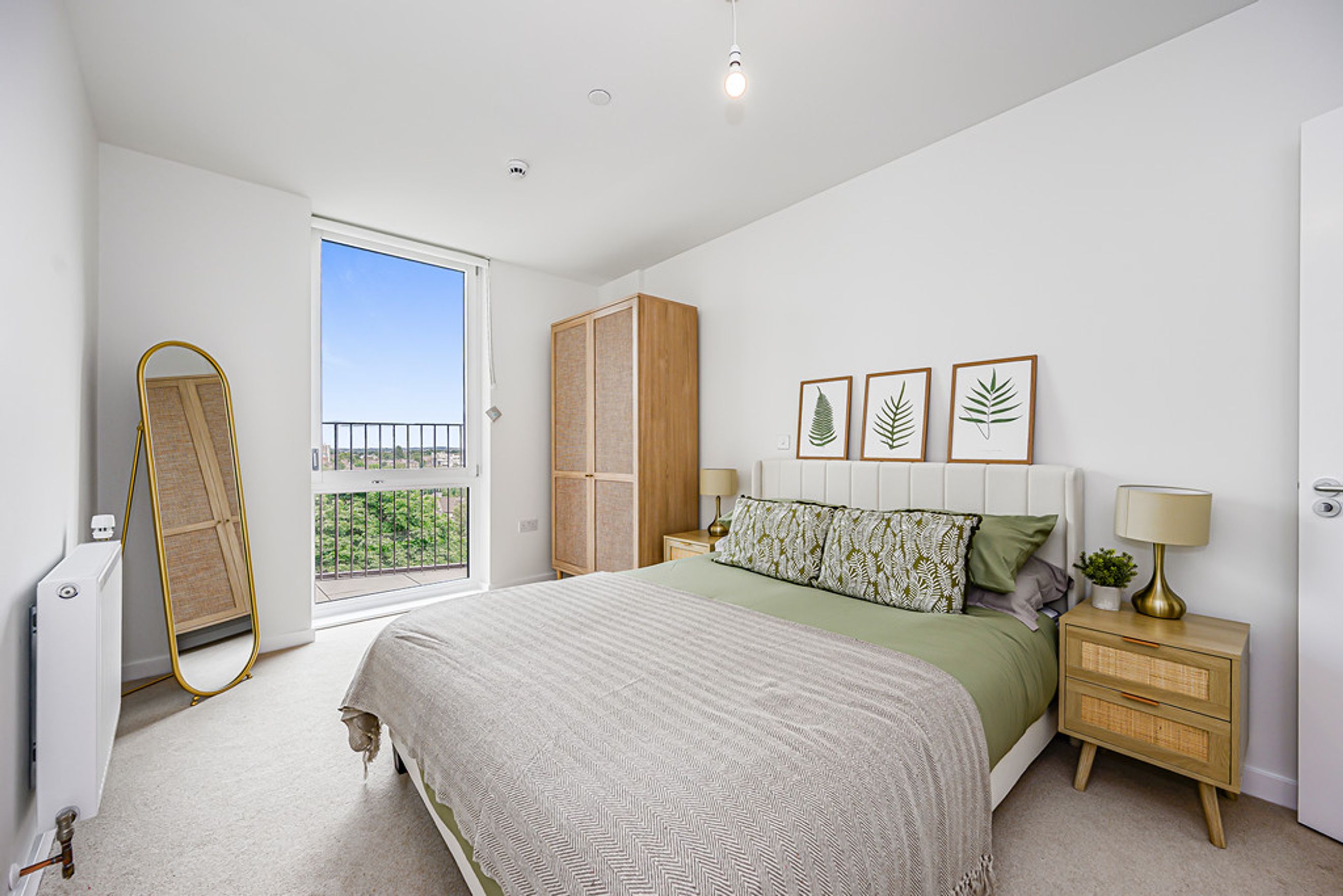 A bedroom with a bed, wardrobe, and a large window.