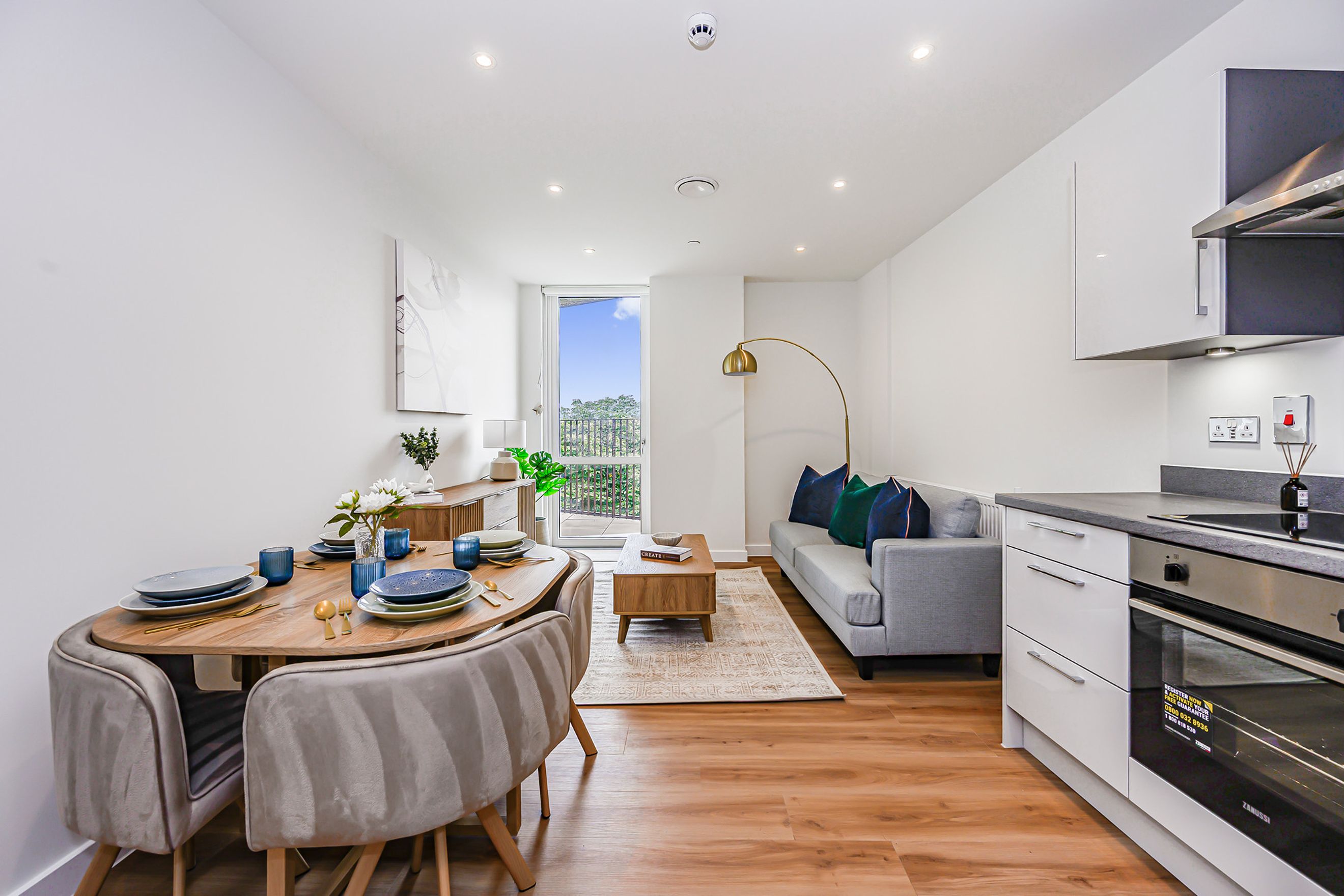 A dining area and living room with a kitchen in a modern apartment.