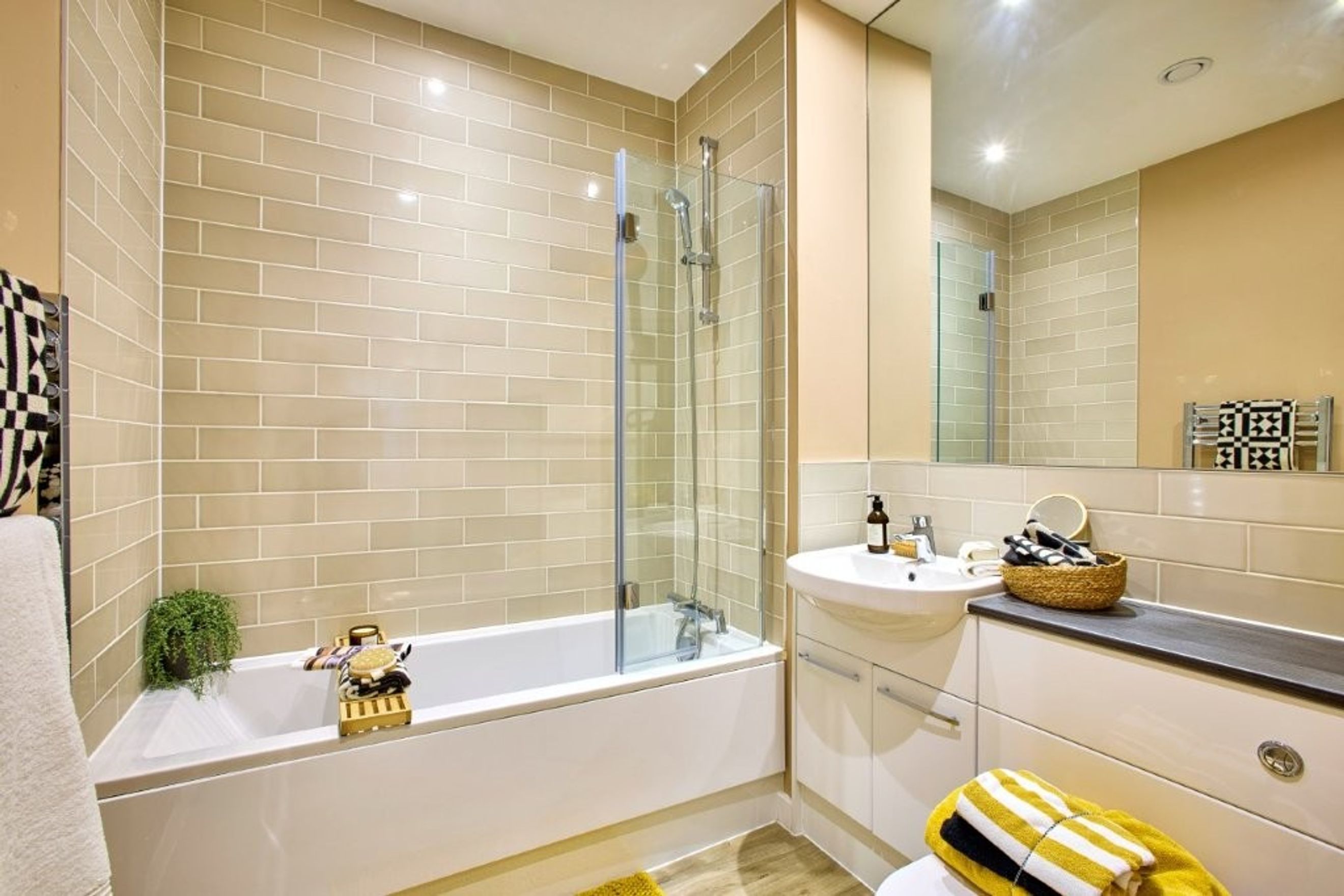 A bathroom with a bathtub, shower, sink, and vanity.