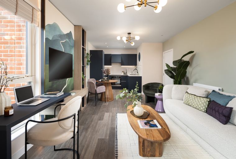 A living room and kitchen area with a sofa, coffee table, dining table, and kitchen cabinets.