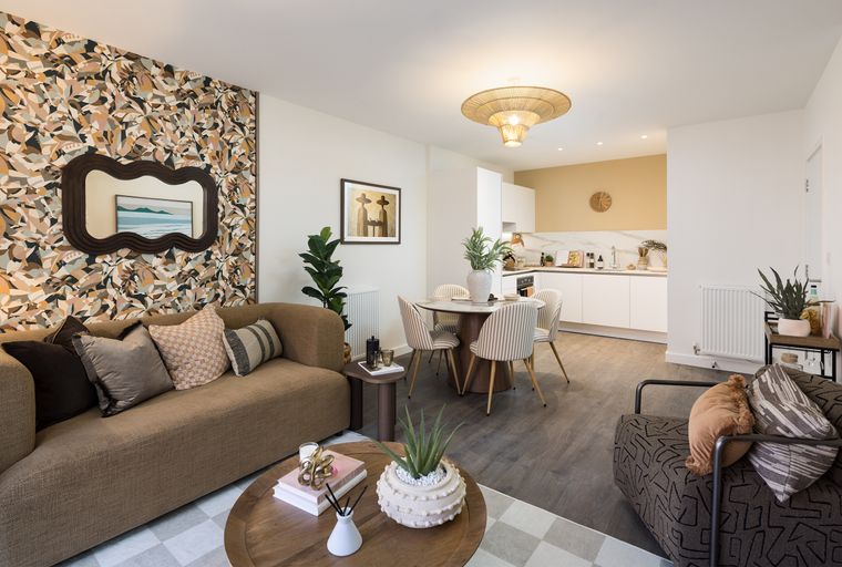 A living and dining area with a kitchen in the background.