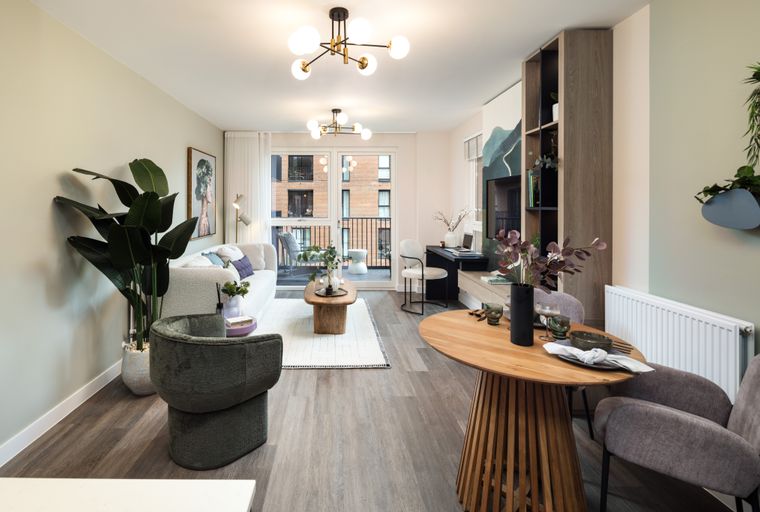 A living and dining room with a sofa, coffee table, dining table, and chairs.
