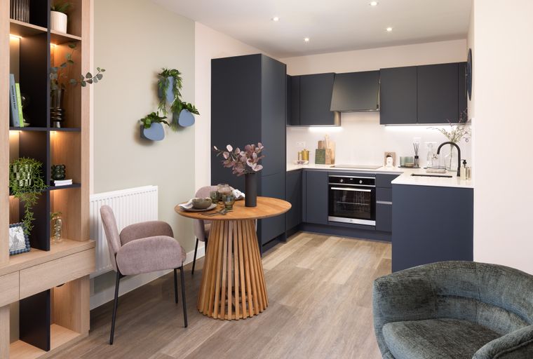 A dining area and kitchen with a table, chairs, and dark cabinets.