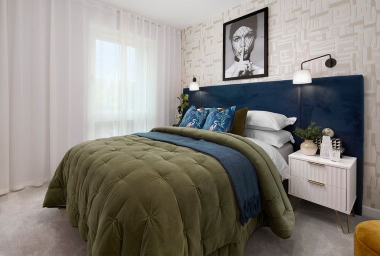 A bedroom with a bed, nightstand, and window with curtains.