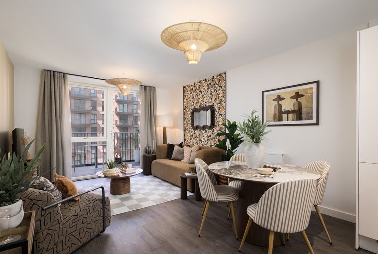 A dining and living area with a marble-top table, chairs, a sofa, and a patterned accent wall.