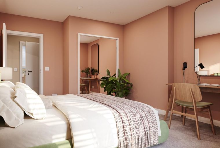 A bedroom with a bed, a vanity, and a wardrobe.