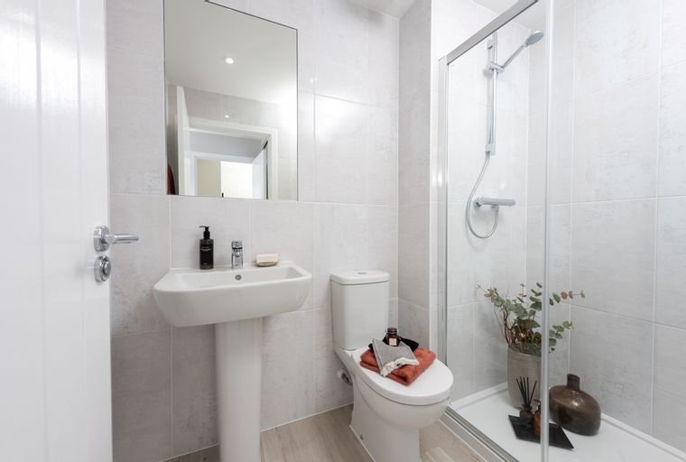 A bathroom with a sink, toilet, and shower.