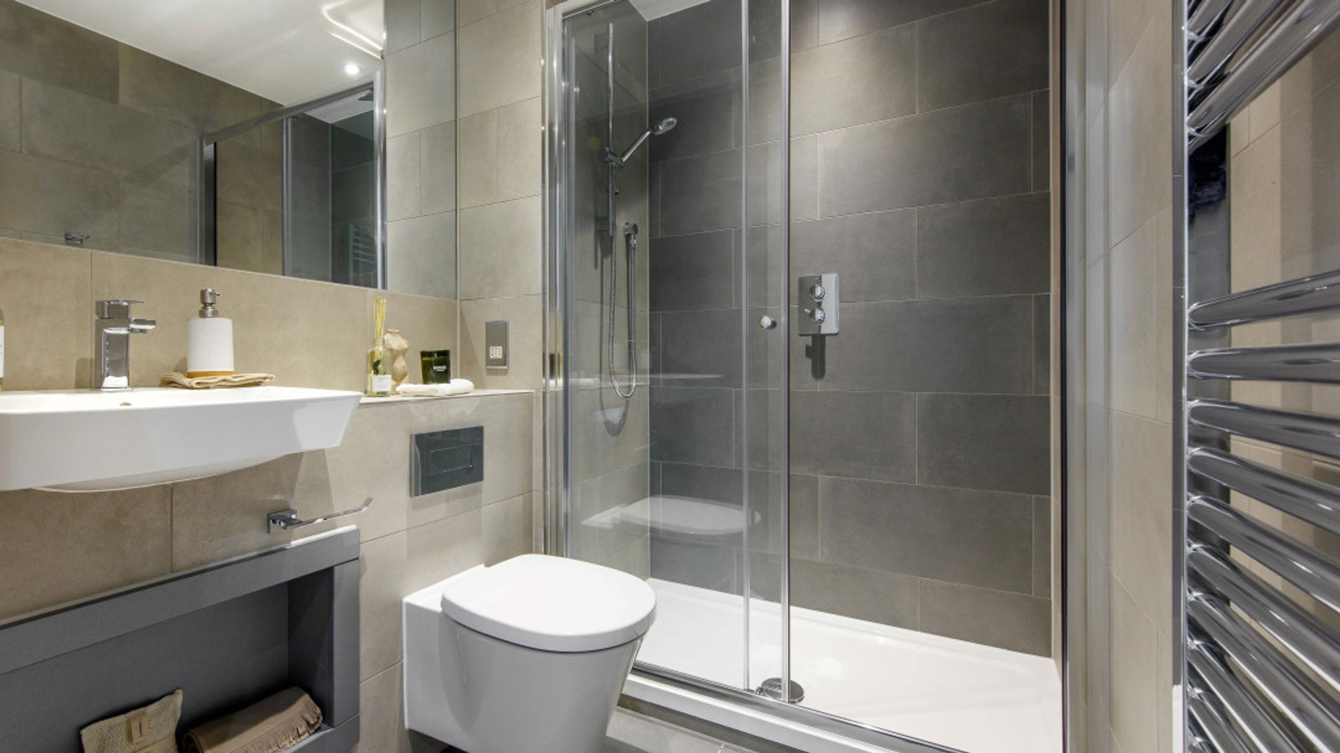 A bathroom with a sink, toilet, and a glass-enclosed shower.