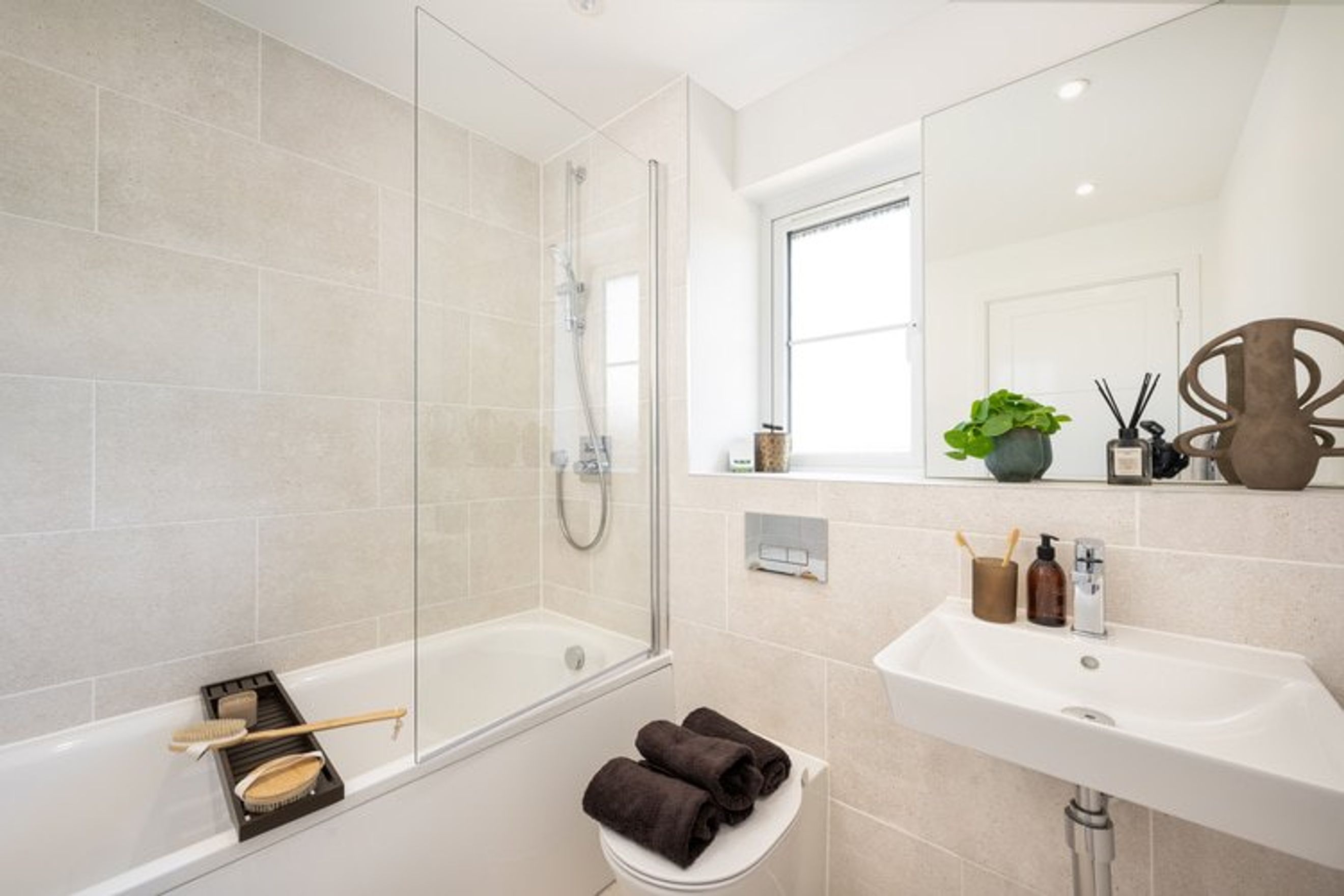 A bathroom with a bathtub, shower, sink, and mirror.