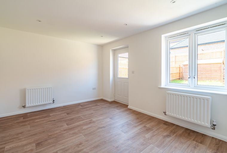 A room with a white radiator, a white door, and a window.